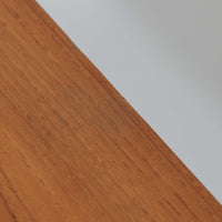 Johannes Andersenがデザインし、C.F.C. Silkeborgが製作した幅200cmのサイドボードです。チーク材の豊かな木目を活かした滑らかな曲面フレームと、横へ流れるように開閉する蛇腹扉が印象的で、端正さの中に軽やかなリズムを生み出します。中央の4段引き出しと両側の収納スペースにより高い収納力を備え、内部の棚板は可動式で実用性も良好。すらりと伸びる脚部が全体に洗練された印象を与え、空間に北欧ビンテージならではの気品と存在感をもたらします。