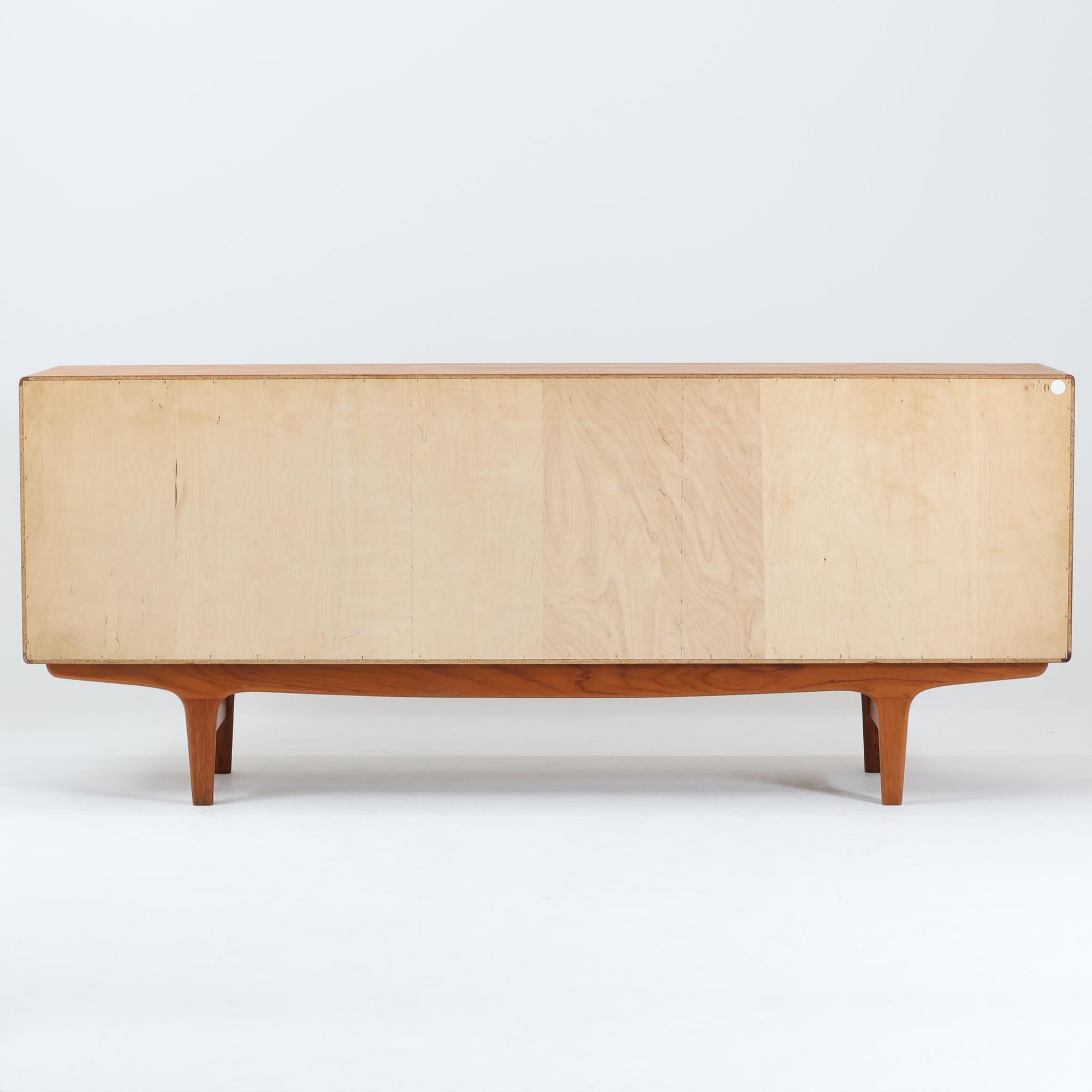 Johannes Andersenがデザインし、C.F.C. Silkeborgが製作した幅200cmのサイドボードです。チーク材の豊かな木目を活かした滑らかな曲面フレームと、横へ流れるように開閉する蛇腹扉が印象的で、端正さの中に軽やかなリズムを生み出します。中央の4段引き出しと両側の収納スペースにより高い収納力を備え、内部の棚板は可動式で実用性も良好。すらりと伸びる脚部が全体に洗練された印象を与え、空間に北欧ビンテージならではの気品と存在感をもたらします。