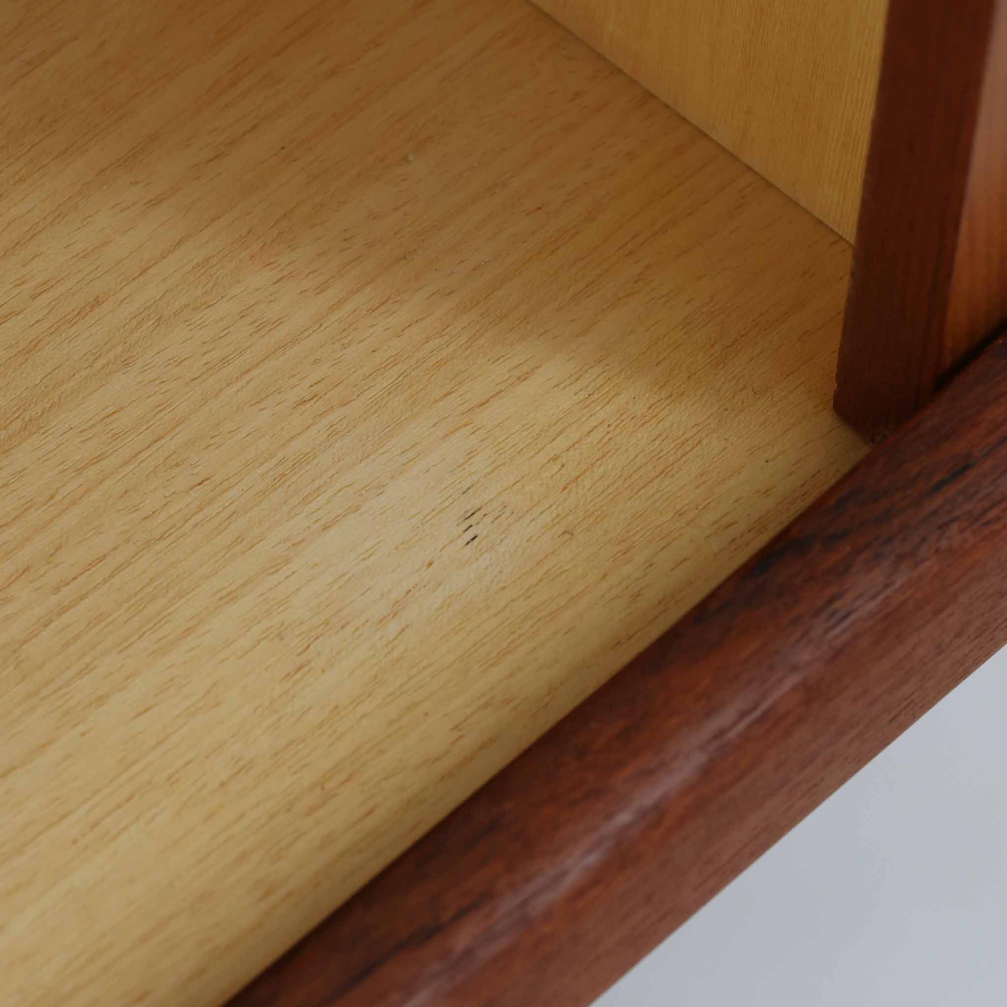 Johannes Andersenがデザインし、C.F.C. Silkeborgが製作した幅200cmのサイドボードです。チーク材の豊かな木目を活かした滑らかな曲面フレームと、横へ流れるように開閉する蛇腹扉が印象的で、端正さの中に軽やかなリズムを生み出します。中央の4段引き出しと両側の収納スペースにより高い収納力を備え、内部の棚板は可動式で実用性も良好。すらりと伸びる脚部が全体に洗練された印象を与え、空間に北欧ビンテージならではの気品と存在感をもたらします。