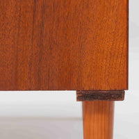 チーク材とビーチ材を組み合わせた北欧ビンテージのローボードで、直線的で端正なフォルムの中に素材の表情が美しく表れた一台です。引き戸仕様の前面は空間をすっきりと見せ、コンパクトなサイズ感ながら内部は左右に分かれた収納構造で、オーディオ機器や書類、小物類まで整理しやすい設計です。脚付き構造による軽やかな佇まいと、経年によって深みを増した木肌の風合いが、当時の丁寧なつくりとビンテージならではの存在感を感じさせ、リビングや書斎、寝室の収納家具として幅広く活躍します。