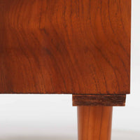 チーク材とビーチ材を組み合わせた北欧ビンテージのローボードで、直線的で端正なフォルムの中に素材の表情が美しく表れた一台です。引き戸仕様の前面は空間をすっきりと見せ、コンパクトなサイズ感ながら内部は左右に分かれた収納構造で、オーディオ機器や書類、小物類まで整理しやすい設計です。脚付き構造による軽やかな佇まいと、経年によって深みを増した木肌の風合いが、当時の丁寧なつくりとビンテージならではの存在感を感じさせ、リビングや書斎、寝室の収納家具として幅広く活躍します。