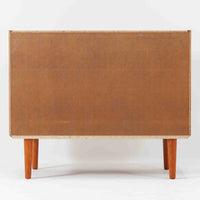 チーク材とビーチ材を組み合わせた北欧ビンテージのローボードで、直線的で端正なフォルムの中に素材の表情が美しく表れた一台です。引き戸仕様の前面は空間をすっきりと見せ、コンパクトなサイズ感ながら内部は左右に分かれた収納構造で、オーディオ機器や書類、小物類まで整理しやすい設計です。脚付き構造による軽やかな佇まいと、経年によって深みを増した木肌の風合いが、当時の丁寧なつくりとビンテージならではの存在感を感じさせ、リビングや書斎、寝室の収納家具として幅広く活躍します。