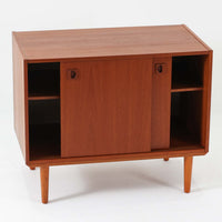 チーク材とビーチ材を組み合わせた北欧ビンテージのローボードで、直線的で端正なフォルムの中に素材の表情が美しく表れた一台です。引き戸仕様の前面は空間をすっきりと見せ、コンパクトなサイズ感ながら内部は左右に分かれた収納構造で、オーディオ機器や書類、小物類まで整理しやすい設計です。脚付き構造による軽やかな佇まいと、経年によって深みを増した木肌の風合いが、当時の丁寧なつくりとビンテージならではの存在感を感じさせ、リビングや書斎、寝室の収納家具として幅広く活躍します。