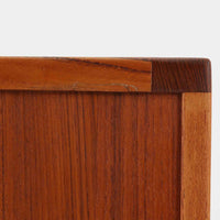 レナート・ベンダーがデザインし、Ulferts Mobler社により製作されたCoronaキャビネットは、小ぶりなサイズ感と端正な佇まいが魅力の北欧ビンテージ家具です。チーク材の美しい木目を活かしたシンプルな箱型構造に、脚部の控えめな意匠が軽やかさを添えています。取っ手部分には異素材となるローズウッドが用いられており、チーク材とのコントラストがさりげないアクセントとして全体の表情を引き締めています。内部は使いやすい収納空間を備え、食器や書類、小物類の整理に適しており、リビングや書斎、玄関周りなど幅広いシーンで活躍します。年月を経て深みを増した素材感と、丁寧な作りが感じられる一台です。