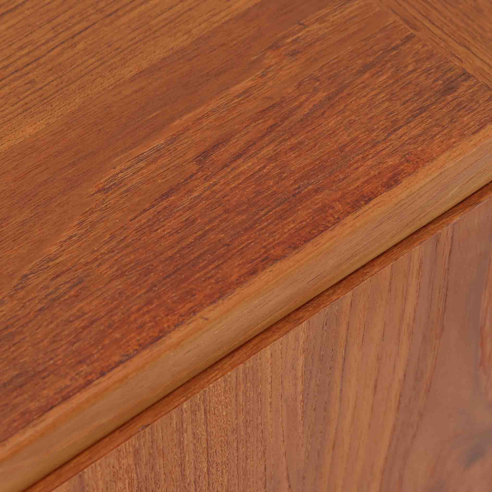 レナート・ベンダーがデザインし、Ulferts Mobler社により製作されたCoronaキャビネットは、小ぶりなサイズ感と端正な佇まいが魅力の北欧ビンテージ家具です。チーク材の美しい木目を活かしたシンプルな箱型構造に、脚部の控えめな意匠が軽やかさを添えています。取っ手部分には異素材となるローズウッドが用いられており、チーク材とのコントラストがさりげないアクセントとして全体の表情を引き締めています。内部は使いやすい収納空間を備え、食器や書類、小物類の整理に適しており、リビングや書斎、玄関周りなど幅広いシーンで活躍します。年月を経て深みを増した素材感と、丁寧な作りが感じられる一台です。