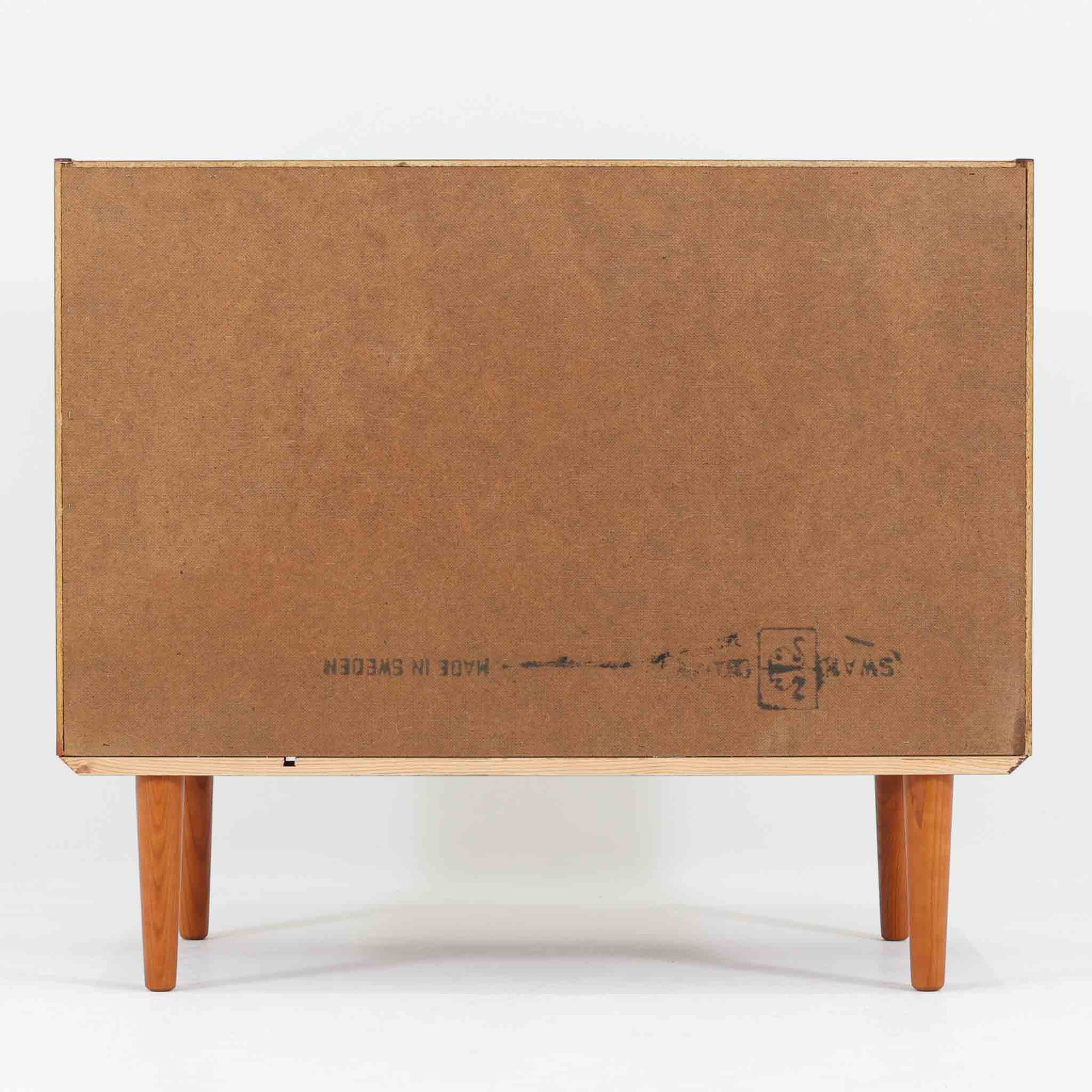 スウェーデン製ボードです。チーク材の温かみある木目を活かしたシンプルな箱型フォルムに、小ぶりな取っ手が愛らしいアクセントとなっています。引き戸仕様のため開閉スペースを取らず、内部には棚板を備え実用性も良好。幅88cmのコンパクトなサイズ感で、リビングや玄関、寝室など様々な空間に取り入れやすい一台です。経年により深みを増した木肌が北欧ビンテージならではの落ち着いた存在感を演出します。