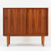 スウェーデン製ボードです。チーク材の温かみある木目を活かしたシンプルな箱型フォルムに、小ぶりな取っ手が愛らしいアクセントとなっています。引き戸仕様のため開閉スペースを取らず、内部には棚板を備え実用性も良好。幅88cmのコンパクトなサイズ感で、リビングや玄関、寝室など様々な空間に取り入れやすい一台です。経年により深みを増した木肌が北欧ビンテージならではの落ち着いた存在感を演出します。