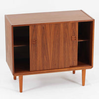 スウェーデン製ボードです。チーク材の温かみある木目を活かしたシンプルな箱型フォルムに、小ぶりな取っ手が愛らしいアクセントとなっています。引き戸仕様のため開閉スペースを取らず、内部には棚板を備え実用性も良好。幅88cmのコンパクトなサイズ感で、リビングや玄関、寝室など様々な空間に取り入れやすい一台です。経年により深みを増した木肌が北欧ビンテージならではの落ち着いた存在感を演出します。