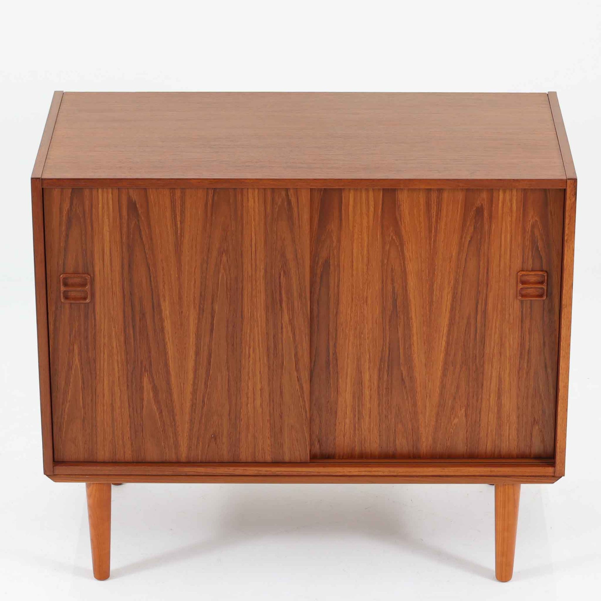 スウェーデン製ボードです。チーク材の温かみある木目を活かしたシンプルな箱型フォルムに、小ぶりな取っ手が愛らしいアクセントとなっています。引き戸仕様のため開閉スペースを取らず、内部には棚板を備え実用性も良好。幅88cmのコンパクトなサイズ感で、リビングや玄関、寝室など様々な空間に取り入れやすい一台です。経年により深みを増した木肌が北欧ビンテージならではの落ち着いた存在感を演出します。