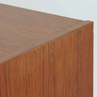 スウェーデン製ボードです。チーク材の温かみある木目を活かしたシンプルな箱型フォルムに、小ぶりな取っ手が愛らしいアクセントとなっています。引き戸仕様のため開閉スペースを取らず、内部には棚板を備え実用性も良好。幅88cmのコンパクトなサイズ感で、リビングや玄関、寝室など様々な空間に取り入れやすい一台です。経年により深みを増した木肌が北欧ビンテージならではの落ち着いた存在感を演出します。