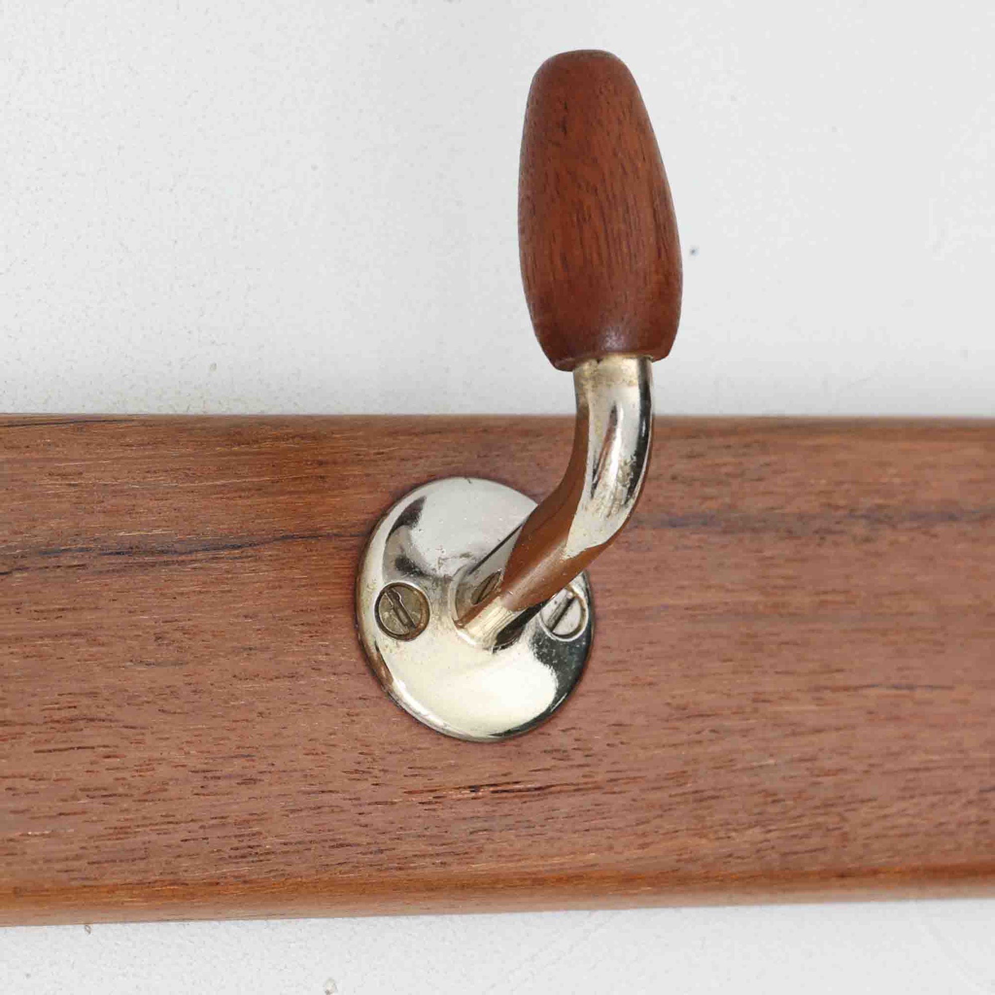 チーク材のベースにメタルフックを組み合わせたデンマーク製の2連ウォールハンガーで、先端には丸みのある木製キャップが付いており掛けた衣類やバッグに優しく、シンプルながら北欧ビンテージらしい温かみのある素材感が魅力です。玄関や寝室、キッチン、ワークスペースなど壁面収納として幅広く活躍し、単体使いはもちろん複数並べて設置することで統一感のあるディスプレイも楽しめます。コンパクトで設置しやすく暮らしの中で気軽に取り入れやすいアイテムです。