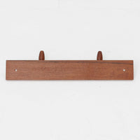 チーク材のベースにメタルフックを組み合わせたデンマーク製の2連ウォールハンガーで、先端には丸みのある木製キャップが付いており掛けた衣類やバッグに優しく、シンプルながら北欧ビンテージらしい温かみのある素材感が魅力です。玄関や寝室、キッチン、ワークスペースなど壁面収納として幅広く活躍し、単体使いはもちろん複数並べて設置することで統一感のあるディスプレイも楽しめます。コンパクトで設置しやすく暮らしの中で気軽に取り入れやすいアイテムです。