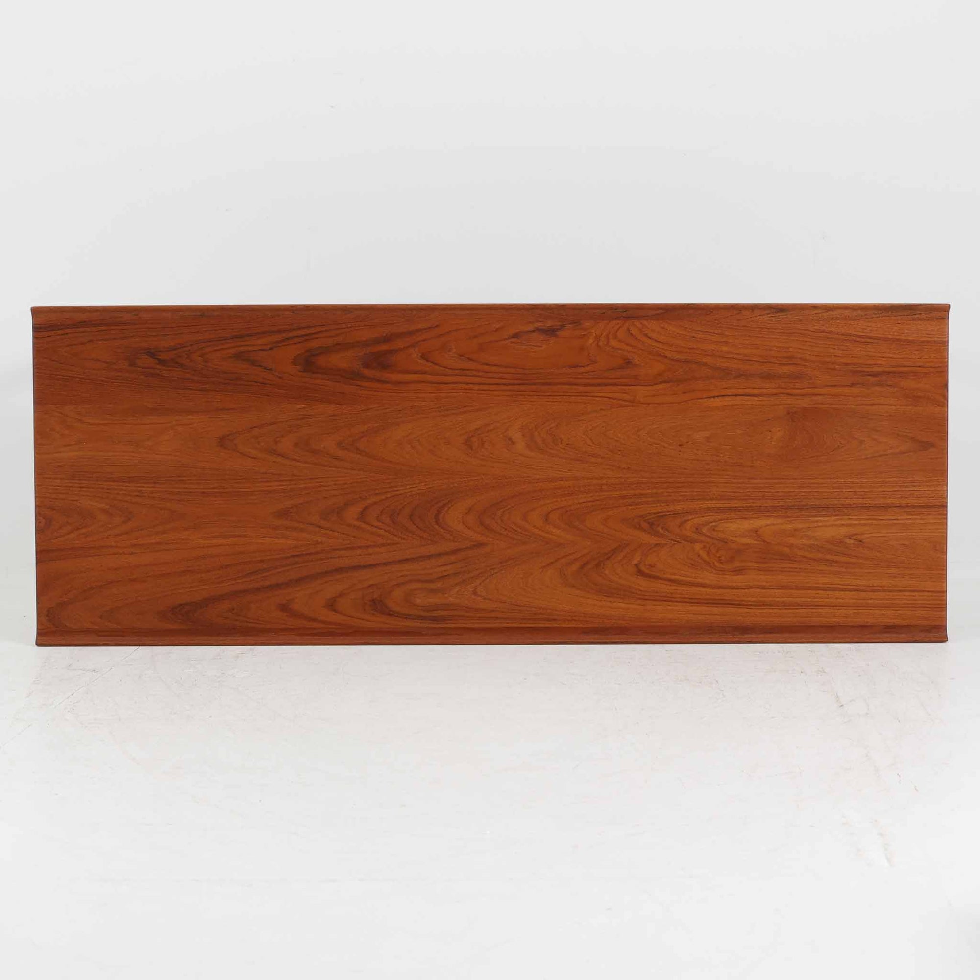 デンマークの名匠フィン・ユールによるデザイン、France &amp; Son社製（前身のFrance &amp; Daverkosen時代に製造）センターテーブル「FD532」です。1950～1957年頃の製造と推測され、チーク無垢材を贅沢に用いた質感豊かな仕上がりが魅力です。脚部から幕板にかけての有機的な曲線や彫刻的なフォルムはフィン・ユールならではの造形美を感じさせ、天板縁のわずかな立ち上がりが軽やかな印象を与えます。FD532には複数の高さバリエーションが存在しますが、本品は低めの約45cmモデルで、ソファ前に合わせやすいバランスの取れたサイズ感。北欧家具らしい温もりと職人技が融合した、希少かつ上質なビンテージテーブルです。