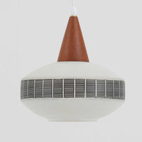 ガラスシェードに幾何学模様の装飾をあしらい、上部にあたたかみのあるウッドパーツを組み合わせた直径24cmのペンダントライトで、素材のコントラストが北欧ビンテージらしい個性を引き立てています。柔らかく広がる乳白ガラスが空間をやさしく照らし、ダイニングやキッチンカウンター、玄関灯としても取り入れやすいサイズ感です。シンプルながら手仕事を感じさせる仕上げや経年による素材の深みが魅力で、単体でアクセントにするほか、複数灯でリズムをつけたコーディネートにもおすすめです。