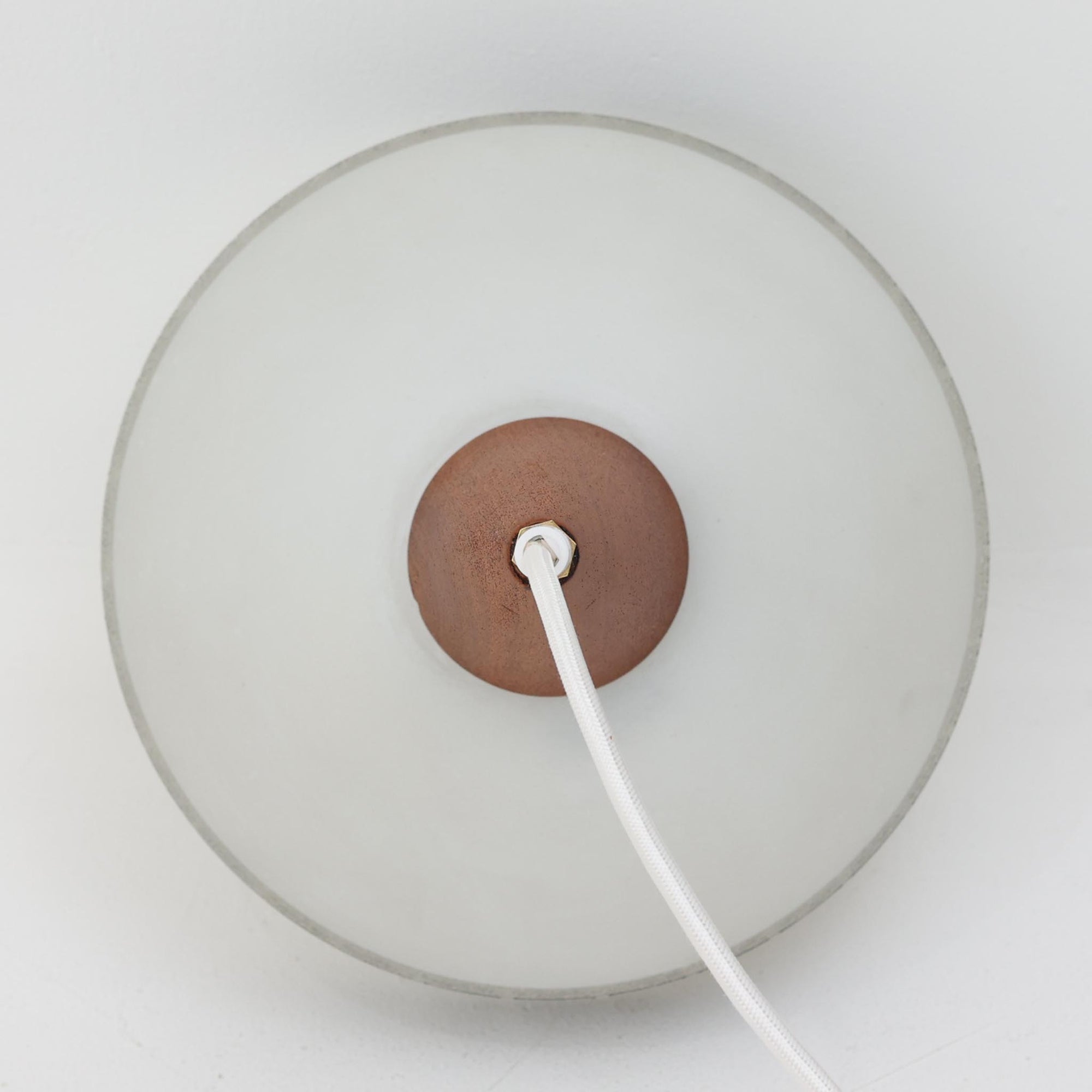 ガラスシェードに幾何学模様の装飾をあしらい、上部にあたたかみのあるウッドパーツを組み合わせた直径24cmのペンダントライトで、素材のコントラストが北欧ビンテージらしい個性を引き立てています。柔らかく広がる乳白ガラスが空間をやさしく照らし、ダイニングやキッチンカウンター、玄関灯としても取り入れやすいサイズ感です。シンプルながら手仕事を感じさせる仕上げや経年による素材の深みが魅力で、単体でアクセントにするほか、複数灯でリズムをつけたコーディネートにもおすすめです。