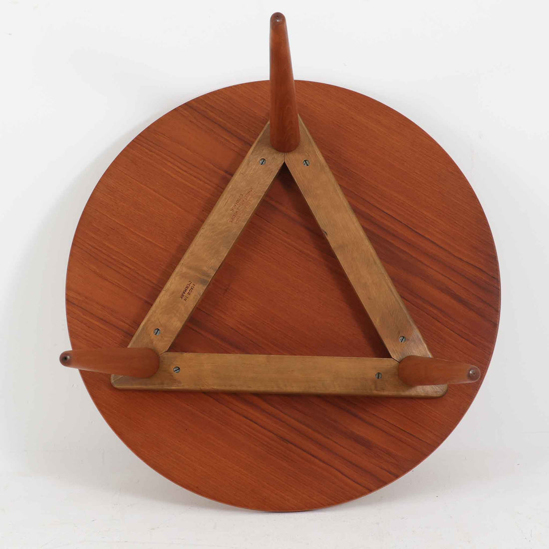 デンマークの巨匠Hans J. Wegner（ハンス・J・ウェグナー）がAndreas Tuck社のためにデザインした「AT8」円形センターテーブルです。チーク材による滑らかな天板と、3本脚の軽やかな構造が特徴で、美しくテーパーのついた脚部が全体に上品な印象を与えます。脚は木製のねじ込み構造になっており、工具を使わずに着脱が可能です。こうしたディテールにもビンテージ期ならではの職人技が感じられます。脚部までチーク材が使用された希少なタイプで、素材の統一感と温かみのある質感が際立ちます。ウェグナーらしいシンプルで機能的な造形と、経年により深みを増したチークの風合いが融合し、リビング空間に上質な北欧のぬくもりを添える一台です。