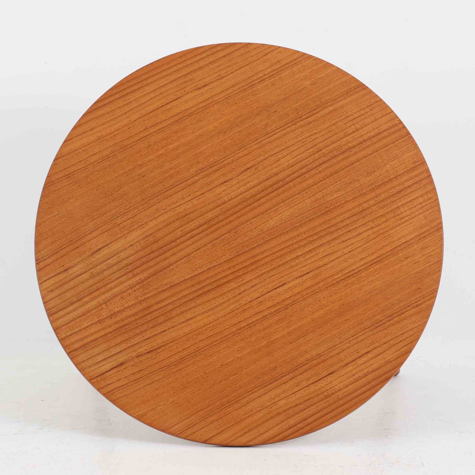 デンマークの巨匠Hans J. Wegner（ハンス・J・ウェグナー）がAndreas Tuck社のためにデザインした「AT8」円形センターテーブルです。チーク材による滑らかな天板と、3本脚の軽やかな構造が特徴で、美しくテーパーのついた脚部が全体に上品な印象を与えます。脚は木製のねじ込み構造になっており、工具を使わずに着脱が可能です。こうしたディテールにもビンテージ期ならではの職人技が感じられます。脚部までチーク材が使用された希少なタイプで、素材の統一感と温かみのある質感が際立ちます。ウェグナーらしいシンプルで機能的な造形と、経年により深みを増したチークの風合いが融合し、リビング空間に上質な北欧のぬくもりを添える一台です。