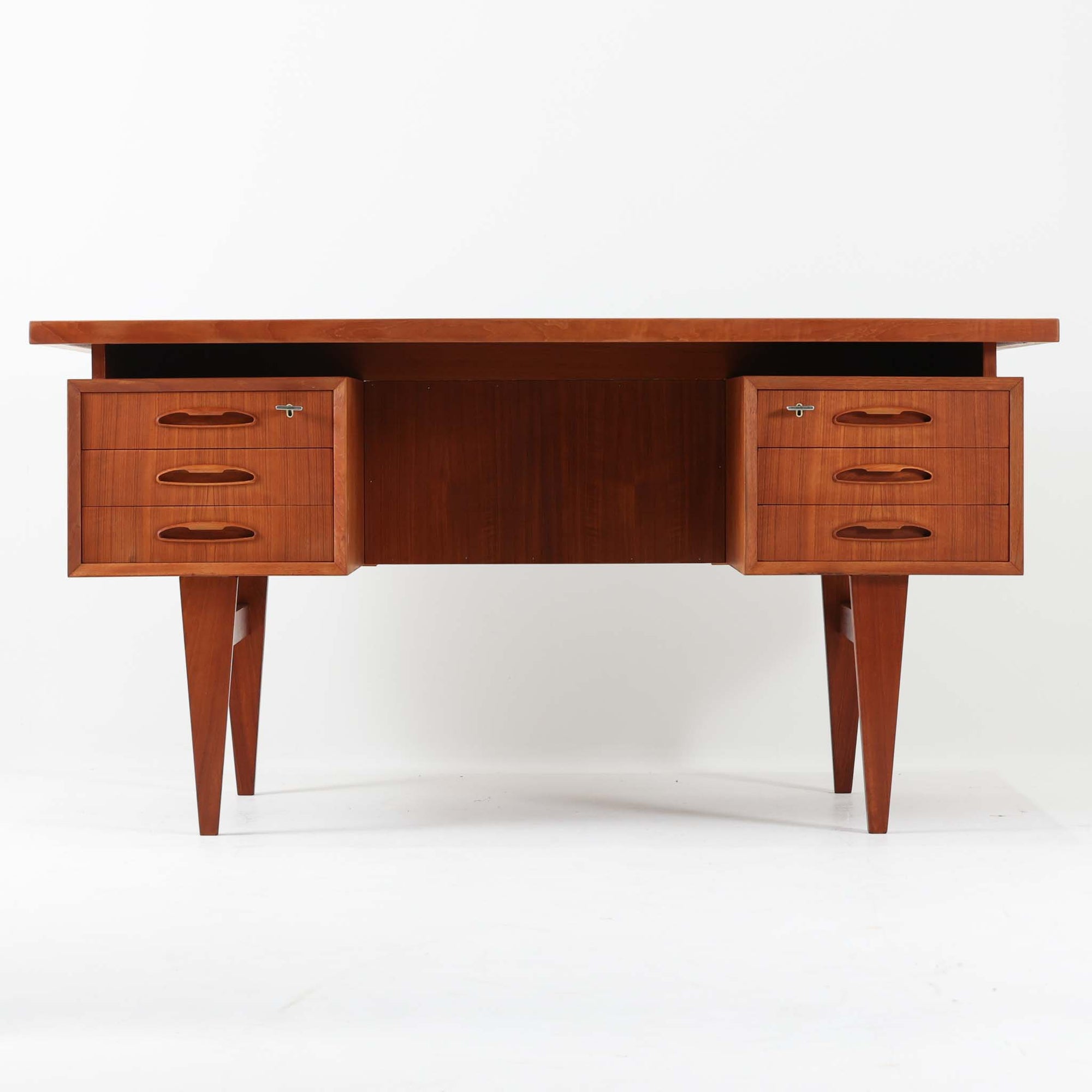 デンマーク製のビンテージ両袖デスクです。チーク材を使用した天板と本体は、美しい木目と温かみのある色合いが魅力で、北欧家具らしい上質な雰囲気を空間にもたらします。左右に備えられた引き出し収納は書類や小物を整理しやすく、作業スペースをすっきり保てる実用的な設計。背面も美しく仕上げられており、空間の中央に配置しても映えるデザインです。細身の脚部が軽やかな印象を与え、書斎やワークスペースに落ち着いたビンテージの存在感を添える一台です。