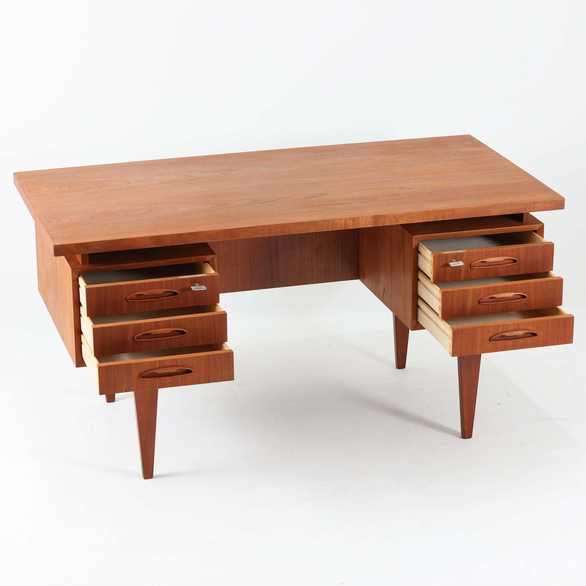 デンマーク製のビンテージ両袖デスクです。チーク材を使用した天板と本体は、美しい木目と温かみのある色合いが魅力で、北欧家具らしい上質な雰囲気を空間にもたらします。左右に備えられた引き出し収納は書類や小物を整理しやすく、作業スペースをすっきり保てる実用的な設計。背面も美しく仕上げられており、空間の中央に配置しても映えるデザインです。細身の脚部が軽やかな印象を与え、書斎やワークスペースに落ち着いたビンテージの存在感を添える一台です。