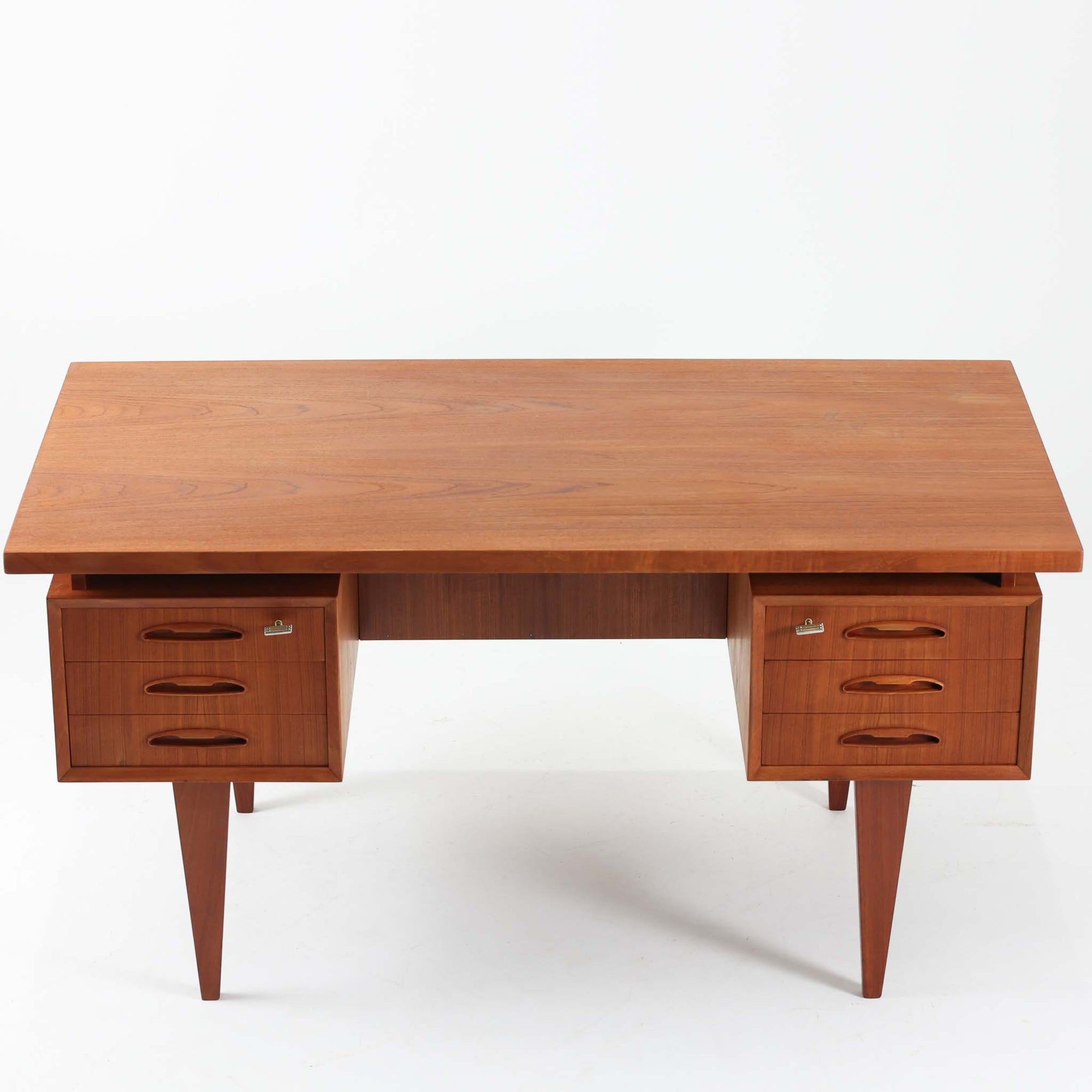 デンマーク製のビンテージ両袖デスクです。チーク材を使用した天板と本体は、美しい木目と温かみのある色合いが魅力で、北欧家具らしい上質な雰囲気を空間にもたらします。左右に備えられた引き出し収納は書類や小物を整理しやすく、作業スペースをすっきり保てる実用的な設計。背面も美しく仕上げられており、空間の中央に配置しても映えるデザインです。細身の脚部が軽やかな印象を与え、書斎やワークスペースに落ち着いたビンテージの存在感を添える一台です。
