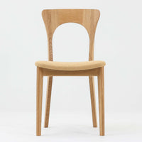 Niels Koefoedが1957年にデザインし、現在はCaso Furnitureより復刻製作されているモデル「Peter」のダイニングチェアです。オーク材の美しい木目を活かしたフレームと、背もたれに大きく設けられたアーチ状の開口部が印象的で、軽やかさと構造的な強度を両立したデザインが特徴です。身体をやさしく受け止める背のラインと、適度なクッション性を備えた座面により、日常使いにおいても快適な座り心地を実現しています。素材の質感を活かしたシンプルな佇まいは、ダイニング空間に自然と馴染み、北欧ミッドセンチュリー期のデザインらしい温かみと洗練を感じさせる一脚です。