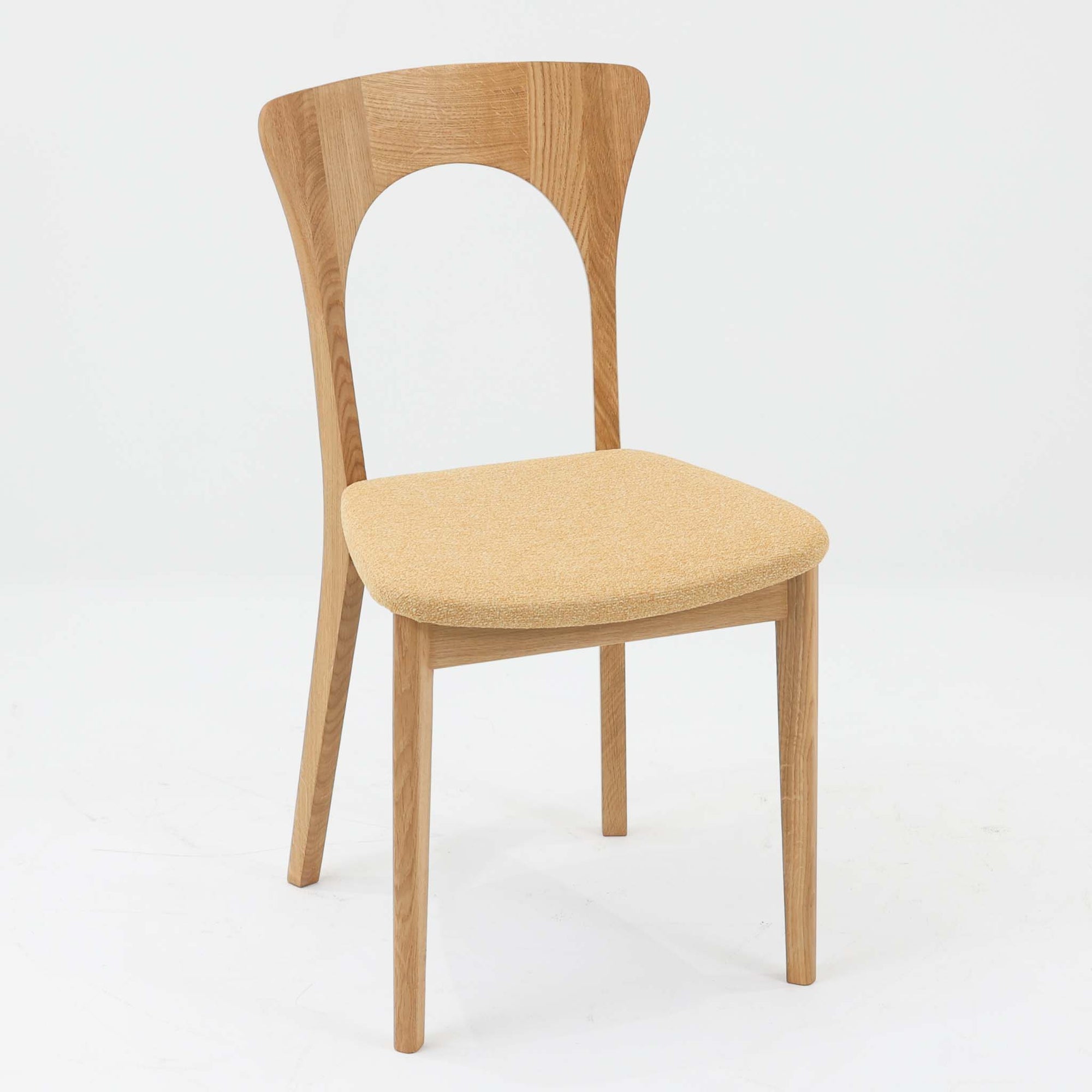 Niels Koefoedが1957年にデザインし、現在はCaso Furnitureより復刻製作されているモデル「Peter」のダイニングチェアです。オーク材の美しい木目を活かしたフレームと、背もたれに大きく設けられたアーチ状の開口部が印象的で、軽やかさと構造的な強度を両立したデザインが特徴です。身体をやさしく受け止める背のラインと、適度なクッション性を備えた座面により、日常使いにおいても快適な座り心地を実現しています。素材の質感を活かしたシンプルな佇まいは、ダイニング空間に自然と馴染み、北欧ミッドセンチュリー期のデザインらしい温かみと洗練を感じさせる一脚です。