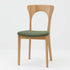 Niels Koefoedが1957年にデザインし、現在はCaso Furnitureより復刻製作されているモデル「Peter」のダイニングチェアです。オーク材の美しい木目を活かしたフレームと、背もたれに大きく設けられたアーチ状の開口部が印象的で、軽やかさと構造的な強度を両立したデザインが特徴です。身体をやさしく受け止める背のラインと、適度なクッション性を備えた座面により、日常使いにおいても快適な座り心地を実現しています。素材の質感を活かしたシンプルな佇まいは、ダイニング空間に自然と馴染み、北欧ミッドセンチュリー期のデザインらしい温かみと洗練を感じさせる一脚です。