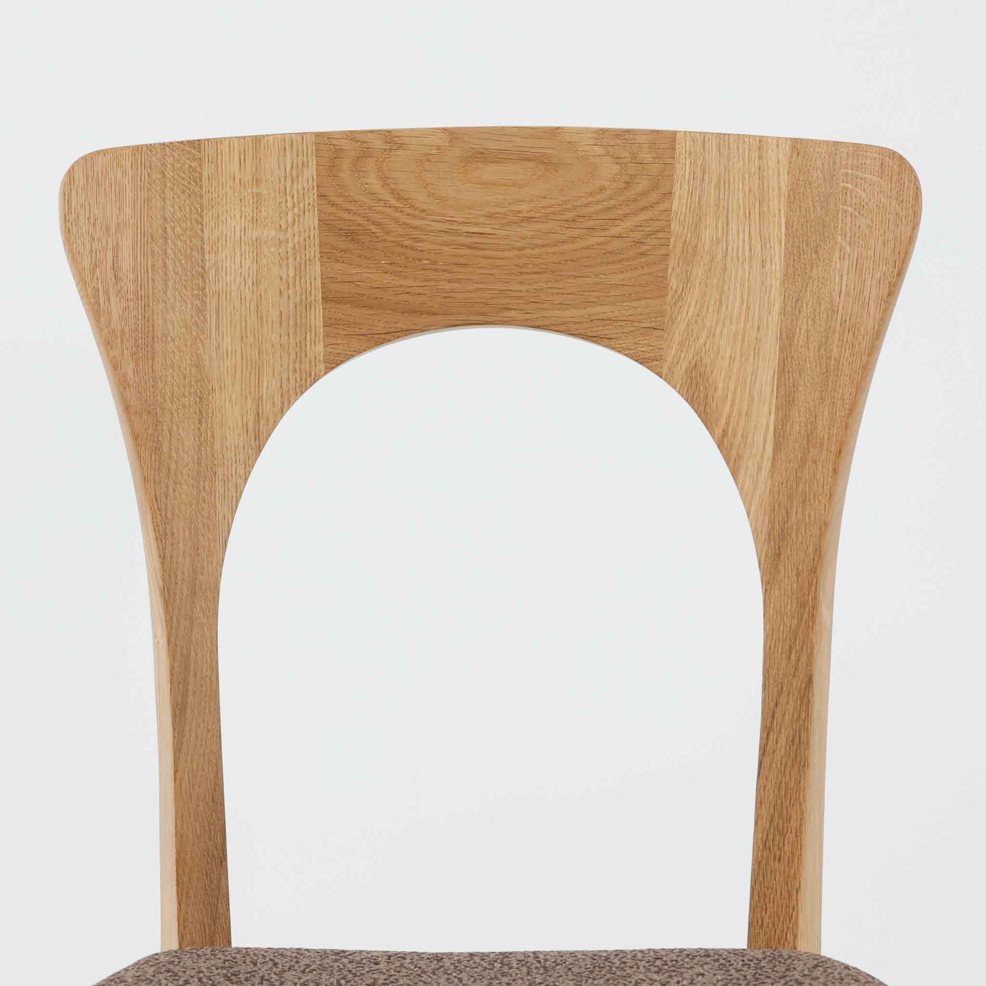 Niels Koefoedが1957年にデザインし、現在はCaso Furnitureより復刻製作されているモデル「Peter」のダイニングチェアです。オーク材の美しい木目を活かしたフレームと、背もたれに大きく設けられたアーチ状の開口部が印象的で、軽やかさと構造的な強度を両立したデザインが特徴です。身体をやさしく受け止める背のラインと、適度なクッション性を備えた座面により、日常使いにおいても快適な座り心地を実現しています。素材の質感を活かしたシンプルな佇まいは、ダイニング空間に自然と馴染み、北欧ミッドセンチュリー期のデザインらしい温かみと洗練を感じさせる一脚です。