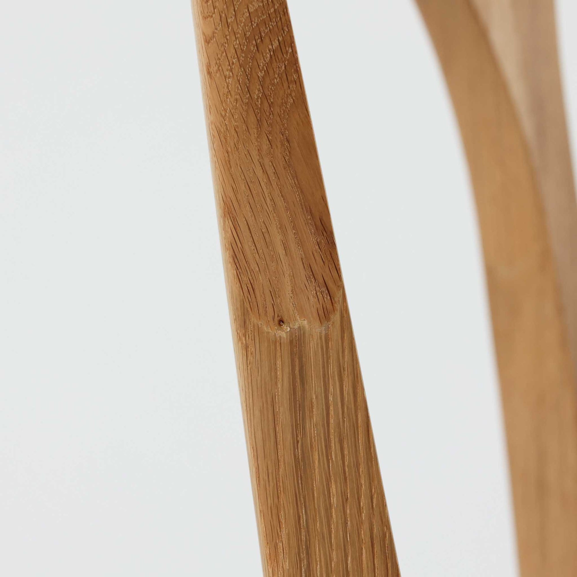 Niels Koefoedが1957年にデザインし、現在はCaso Furnitureより復刻製作されているモデル「Peter」のダイニングチェアです。オーク材の美しい木目を活かしたフレームと、背もたれに大きく設けられたアーチ状の開口部が印象的で、軽やかさと構造的な強度を両立したデザインが特徴です。身体をやさしく受け止める背のラインと、適度なクッション性を備えた座面により、日常使いにおいても快適な座り心地を実現しています。素材の質感を活かしたシンプルな佇まいは、ダイニング空間に自然と馴染み、北欧ミッドセンチュリー期のデザインらしい温かみと洗練を感じさせる一脚です。