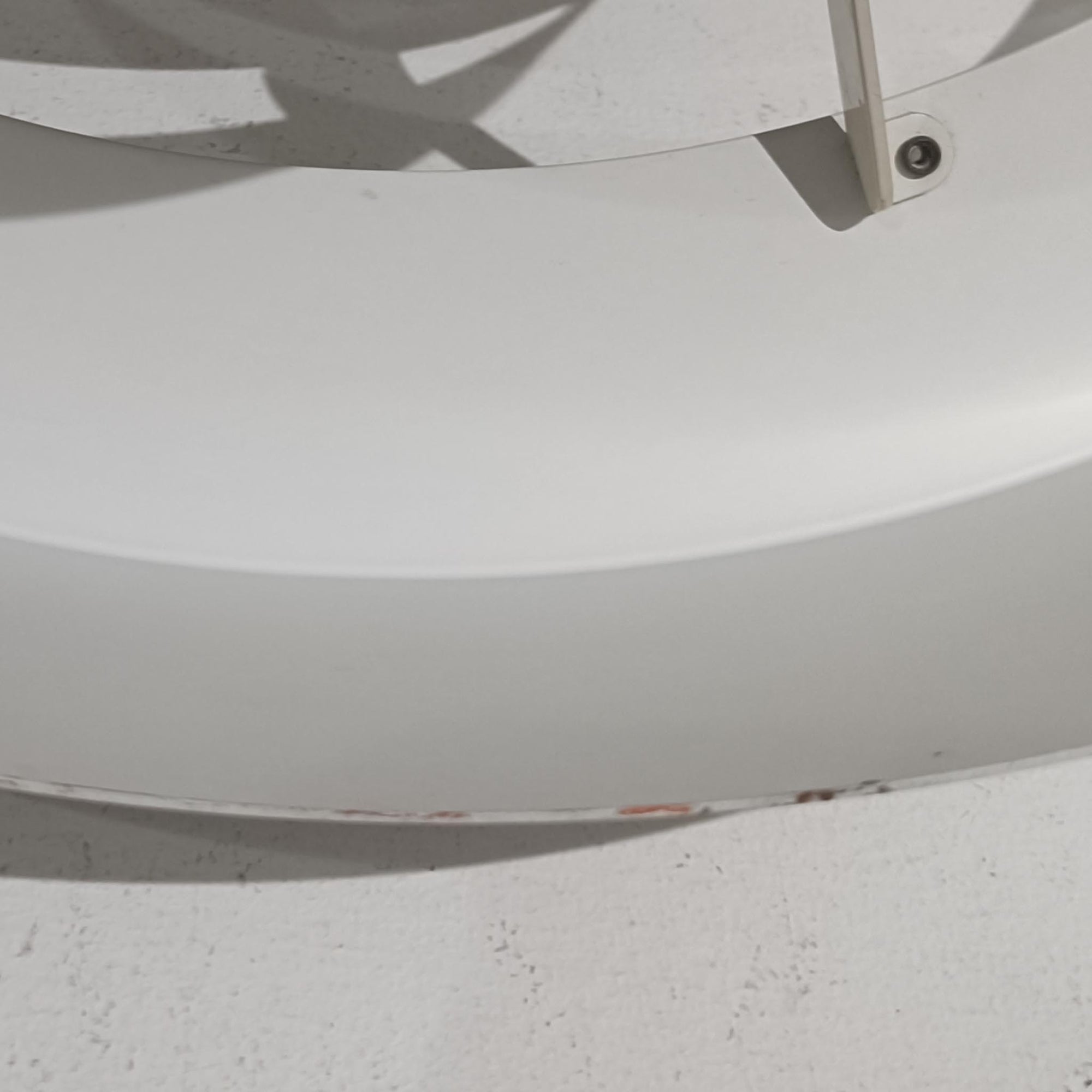 Jo HammerborgがFog &amp; Morupのためにデザインした「Equator」は、直径40cmの存在感あるスチール製ペンダントライトで、赤・黄色・青など多彩なカラーバリエーションが展開されていたモデルとして知られますが、本品は空間に優しく溶け込む上品なホワイトカラーが採用されています。スチール特有の程よい重量感と重厚な佇まいがあり、実際に吊るすとホワイトの柔らかな印象の中にしっかりとした質感が感じられるのも魅力です。同心円状に重なるシェードが光を柔らかく分散させ、眩しさを抑えつつ立体的な陰影を生み出す構造が特徴で、ダイニングやリビングの主照明として落ち着きのあるモダンなアクセントを添えます。ミニマルな造形の中に職人技が凝縮されており、経年で深まった塗装の質感がビンテージならではの魅力を一層引き立てています。