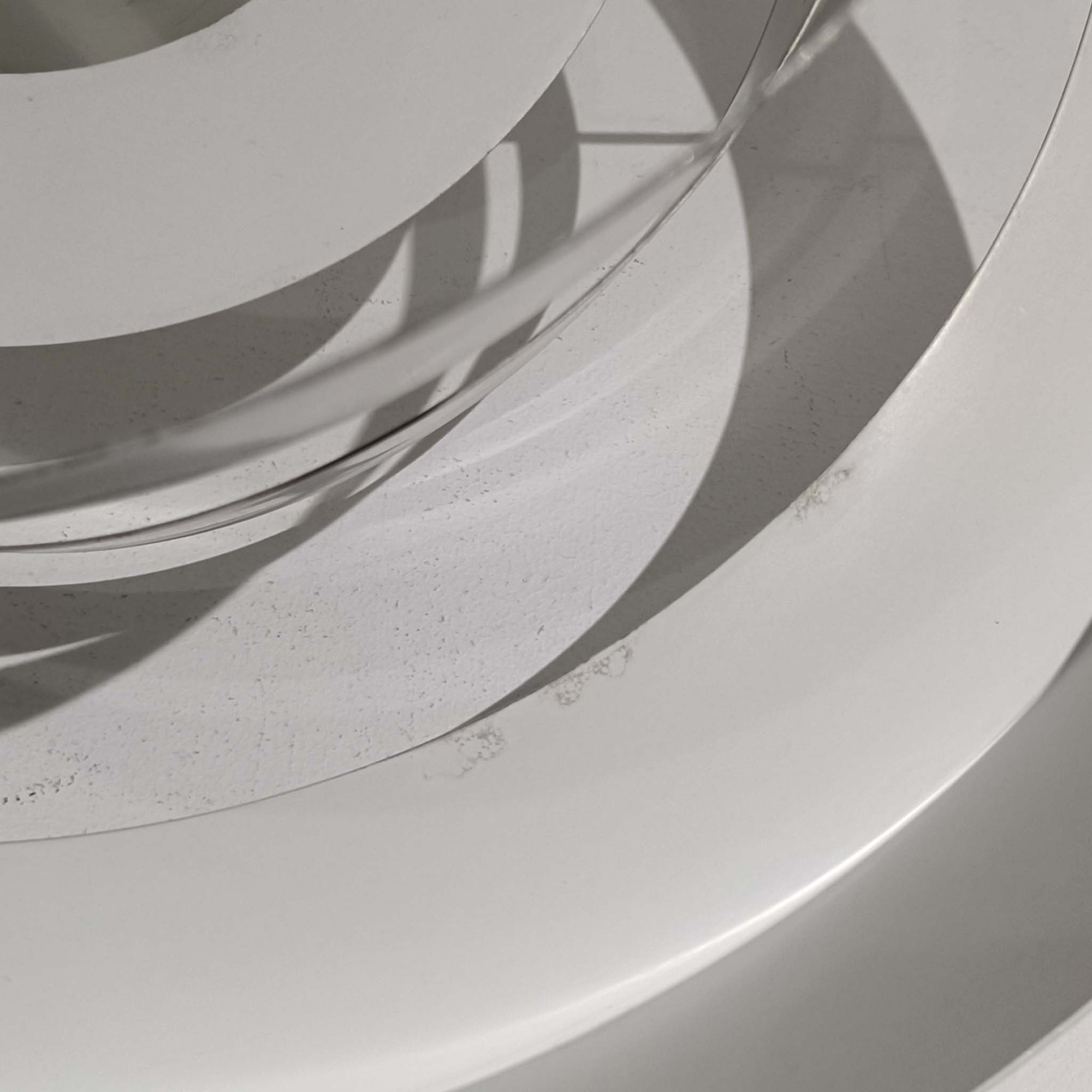 Jo HammerborgがFog &amp; Morupのためにデザインした「Equator」は、直径40cmの存在感あるスチール製ペンダントライトで、赤・黄色・青など多彩なカラーバリエーションが展開されていたモデルとして知られますが、本品は空間に優しく溶け込む上品なホワイトカラーが採用されています。スチール特有の程よい重量感と重厚な佇まいがあり、実際に吊るすとホワイトの柔らかな印象の中にしっかりとした質感が感じられるのも魅力です。同心円状に重なるシェードが光を柔らかく分散させ、眩しさを抑えつつ立体的な陰影を生み出す構造が特徴で、ダイニングやリビングの主照明として落ち着きのあるモダンなアクセントを添えます。ミニマルな造形の中に職人技が凝縮されており、経年で深まった塗装の質感がビンテージならではの魅力を一層引き立てています。