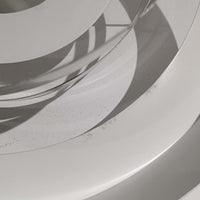 Jo HammerborgがFog & Morupのためにデザインした「Equator」は、直径40cmの存在感あるスチール製ペンダントライトで、赤・黄色・青など多彩なカラーバリエーションが展開されていたモデルとして知られますが、本品は空間に優しく溶け込む上品なホワイトカラーが採用されています。スチール特有の程よい重量感と重厚な佇まいがあり、実際に吊るすとホワイトの柔らかな印象の中にしっかりとした質感が感じられるのも魅力です。同心円状に重なるシェードが光を柔らかく分散させ、眩しさを抑えつつ立体的な陰影を生み出す構造が特徴で、ダイニングやリビングの主照明として落ち着きのあるモダンなアクセントを添えます。ミニマルな造形の中に職人技が凝縮されており、経年で深まった塗装の質感がビンテージならではの魅力を一層引き立てています。