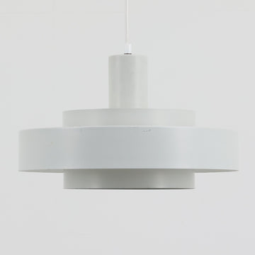 Jo HammerborgがFog & Morupのためにデザインした「Equator」は、直径40cmの存在感あるスチール製ペンダントライトで、赤・黄色・青など多彩なカラーバリエーションが展開されていたモデルとして知られますが、本品は空間に優しく溶け込む上品なホワイトカラーが採用されています。スチール特有の程よい重量感と重厚な佇まいがあり、実際に吊るすとホワイトの柔らかな印象の中にしっかりとした質感が感じられるのも魅力です。同心円状に重なるシェードが光を柔らかく分散させ、眩しさを抑えつつ立体的な陰影を生み出す構造が特徴で、ダイニングやリビングの主照明として落ち着きのあるモダンなアクセントを添えます。ミニマルな造形の中に職人技が凝縮されており、経年で深まった塗装の質感がビンテージならではの魅力を一層引き立てています。