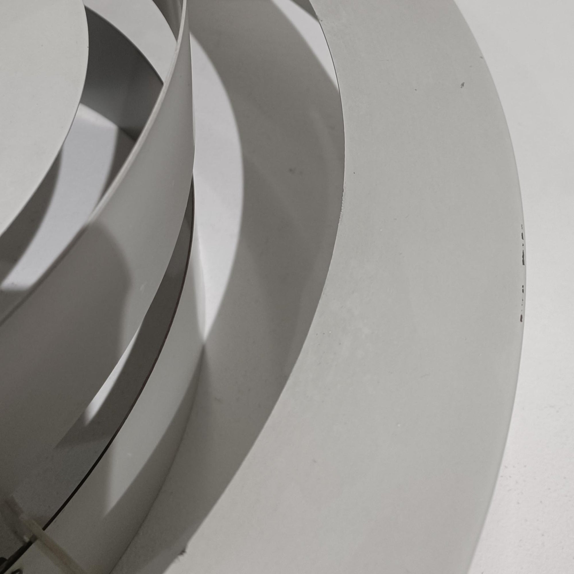 Jo HammerborgがFog &amp; Morupのためにデザインした「Equator」は、直径40cmの存在感あるスチール製ペンダントライトで、赤・黄色・青など多彩なカラーバリエーションが展開されていたモデルとして知られますが、本品は空間に優しく溶け込む上品なホワイトカラーが採用されています。スチール特有の程よい重量感と重厚な佇まいがあり、実際に吊るすとホワイトの柔らかな印象の中にしっかりとした質感が感じられるのも魅力です。同心円状に重なるシェードが光を柔らかく分散させ、眩しさを抑えつつ立体的な陰影を生み出す構造が特徴で、ダイニングやリビングの主照明として落ち着きのあるモダンなアクセントを添えます。ミニマルな造形の中に職人技が凝縮されており、経年で深まった塗装の質感がビンテージならではの魅力を一層引き立てています。