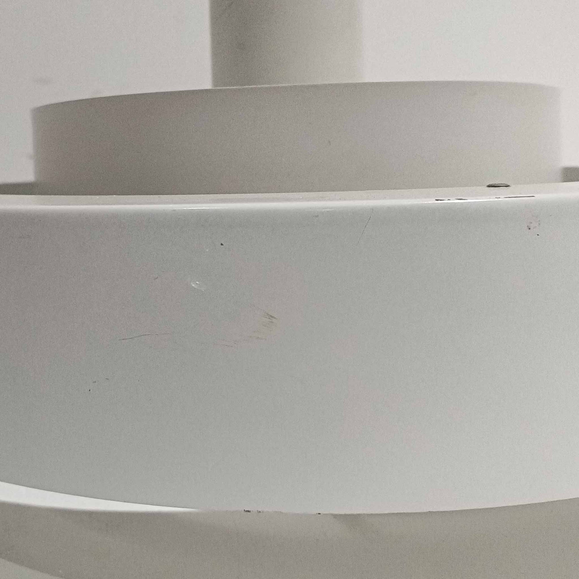 Jo HammerborgがFog &amp; Morupのためにデザインした「Equator」は、直径40cmの存在感あるスチール製ペンダントライトで、赤・黄色・青など多彩なカラーバリエーションが展開されていたモデルとして知られますが、本品は空間に優しく溶け込む上品なホワイトカラーが採用されています。スチール特有の程よい重量感と重厚な佇まいがあり、実際に吊るすとホワイトの柔らかな印象の中にしっかりとした質感が感じられるのも魅力です。同心円状に重なるシェードが光を柔らかく分散させ、眩しさを抑えつつ立体的な陰影を生み出す構造が特徴で、ダイニングやリビングの主照明として落ち着きのあるモダンなアクセントを添えます。ミニマルな造形の中に職人技が凝縮されており、経年で深まった塗装の質感がビンテージならではの魅力を一層引き立てています。