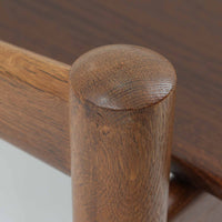 Hans J. Wegnerがデザインし、Getamaが製作したGE530オットマンです。ダークオーク材の力強い木目を活かした角の取れたフレームと、丸脚を組み合わせた端正な構造が特徴で、裏面には刻印も確認できます。程よい厚みのクッションは張り替え済みで、軽やかな生地が木部の深みのある色合いを引き立てます。同シリーズのラウンジチェアと合わせてはもちろん、単体でスツールや補助椅子としても活躍する、北欧ビンテージならではの質実剛健な一品です。