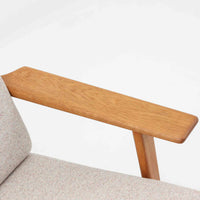 Hans J. Wegnerがデザインし、Getama社によって製作されたGE290は、構造の美しさと快適な座り心地を兼ね備えた北欧ビンテージを代表するシングルソファです。厚みのあるクッションと緩やかに傾斜した背もたれが身体を包み込み、自然と深いリラックス姿勢へと導きます。クッション内部にはビンテージ品ならではのスプリングが内包されており、しっかりとした弾力と安定感のある座り心地を生み出しています。オーク材のフレームは力強さと温かみを併せ持ち、アームから脚部にかけての造形にはウェグナーらしい彫刻的な魅力が感じられます。張地の落ち着いた色合いと、経年により深みを増した木部の表情が調和し、リビングや書斎で長く寄り添う一脚です。