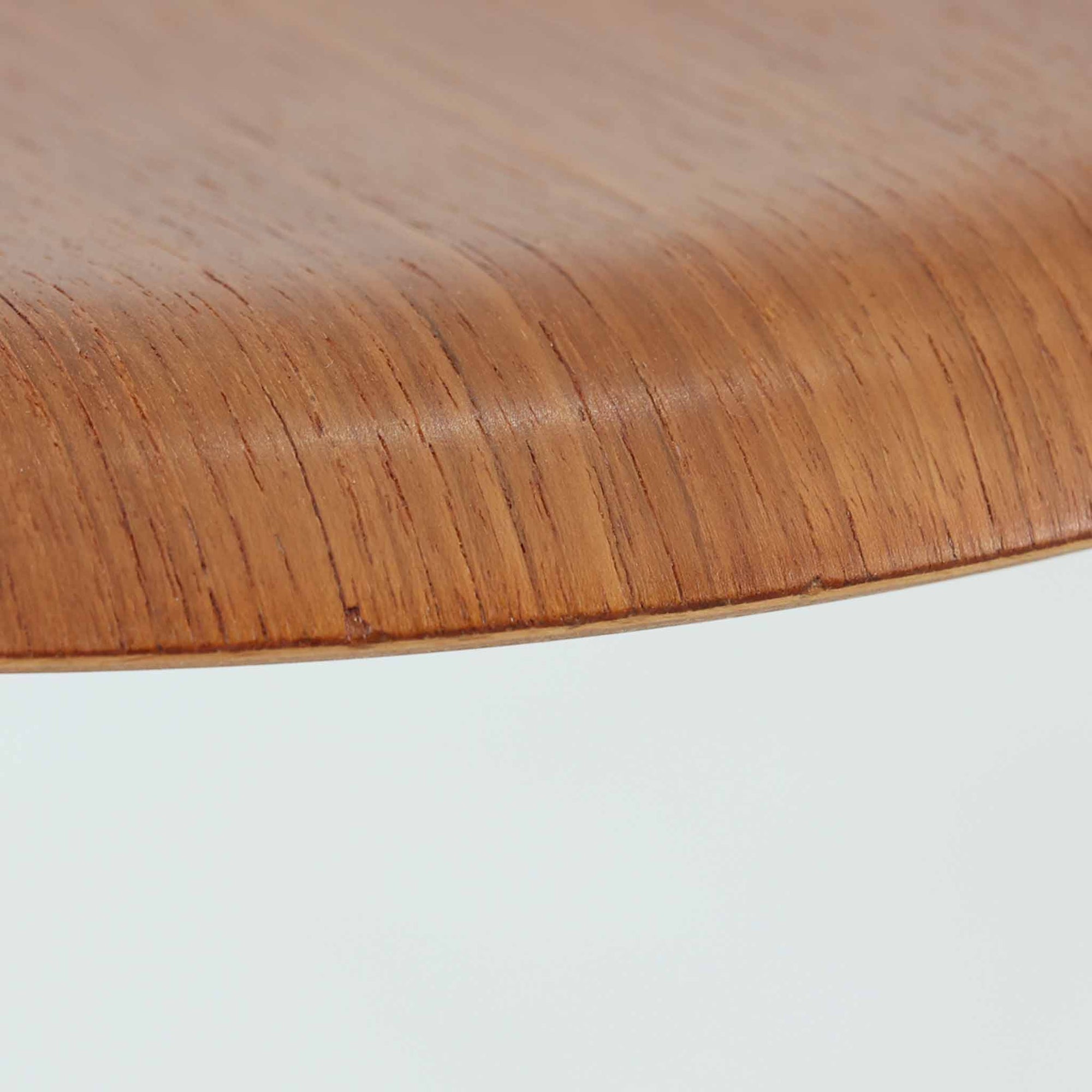 Arne Jacobsen（アルネ・ヤコブセン）がFritz Hansen（フリッツ・ハンセン）のために手掛けた有名なドットスツールは、チーク材の座面とスチールレッグを組み合わせた軽快な佇まいが魅力の北欧ビンテージ家具で、中でも希少なチークモデルとなるこちらは滑らかに成形された丸い座面が身体に心地よくフィットし、わずかに外側へ開いた3本脚が安定感を確保しつつ空間に軽やかな印象を添え、ミニマルな構造に宿る職人技と経年で深まった木肌と金属のコントラストが美しく、ダイニングのサブチェアや玄関、デスク横のサイドスツールとしても取り入れやすい一脚です。