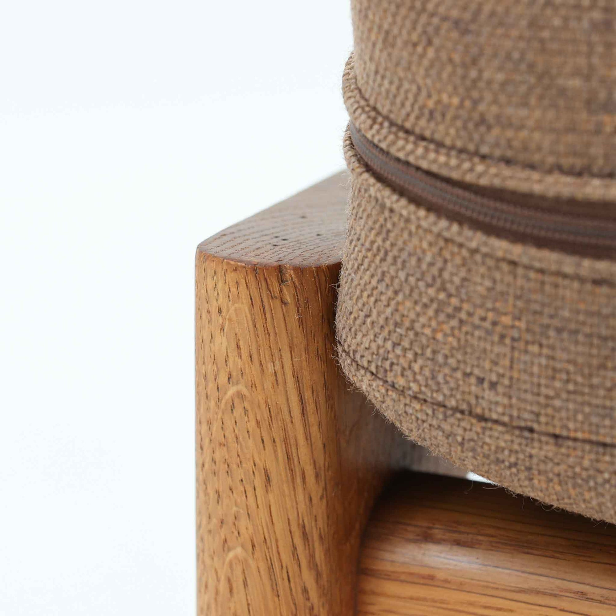 Hans J. Wegnerがデザインし、Getamaが製作したGE290オットマンです。オーク材の美しい木目を活かした無垢フレームは、丸みを帯びた脚部と貫構造により安定感と軽やかさを兼ね備えています。クッションは張り替え済みで、ライトブラウン色の張地が木部の温かな色合いと調和し、落ち着いた印象を与えます。内部にはビンテージ品ならではのスプリングが内包され、弾力ある座り心地も魅力。同シリーズのラウンジチェアと組み合わせてはもちろん、単体でもスツールとして活躍する、経年変化の味わい深い一品です。