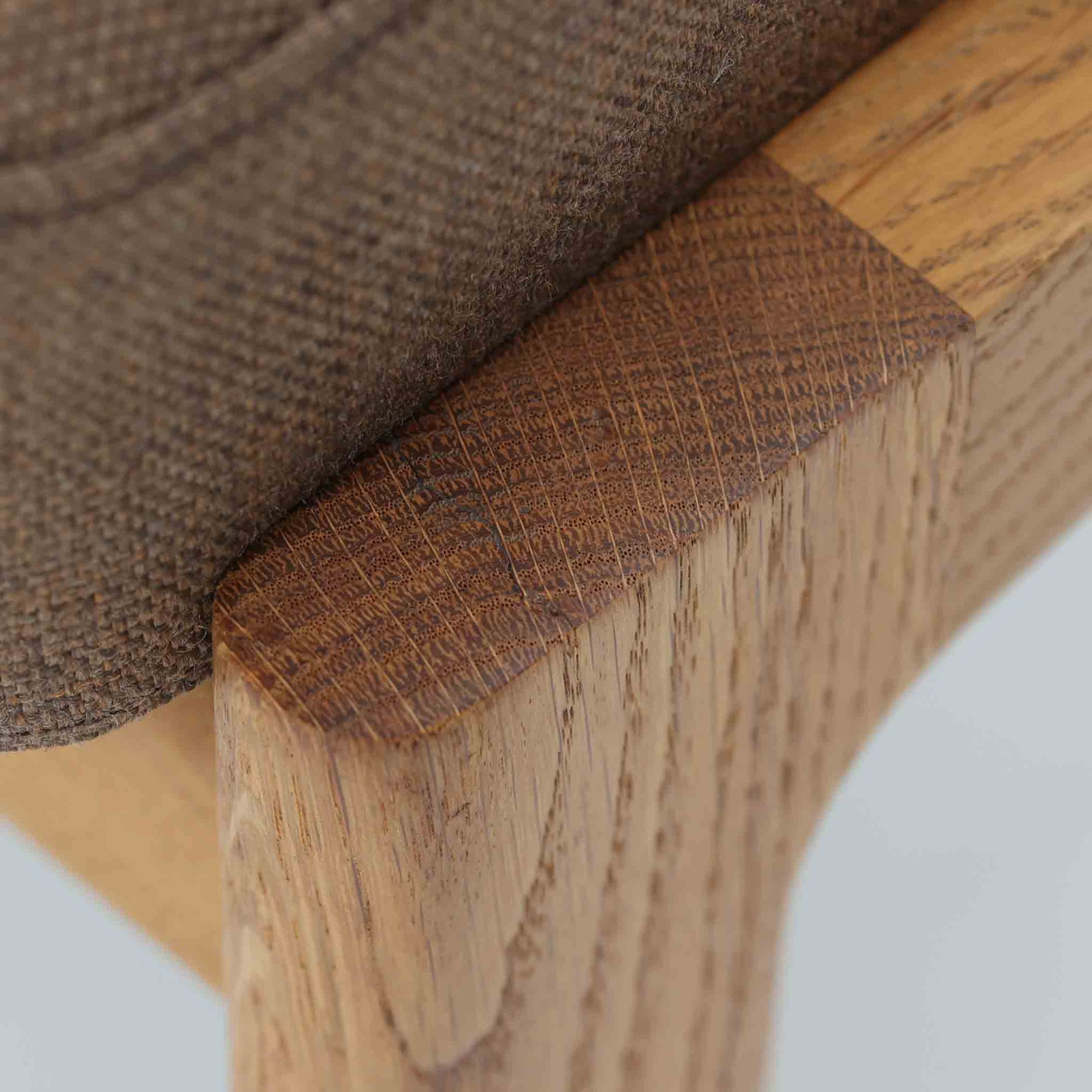 Hans J. Wegnerがデザインし、Getamaが製作したGE290オットマンです。オーク材の美しい木目を活かした無垢フレームは、丸みを帯びた脚部と貫構造により安定感と軽やかさを兼ね備えています。クッションは張り替え済みで、ライトブラウン色の張地が木部の温かな色合いと調和し、落ち着いた印象を与えます。内部にはビンテージ品ならではのスプリングが内包され、弾力ある座り心地も魅力。同シリーズのラウンジチェアと組み合わせてはもちろん、単体でもスツールとして活躍する、経年変化の味わい深い一品です。