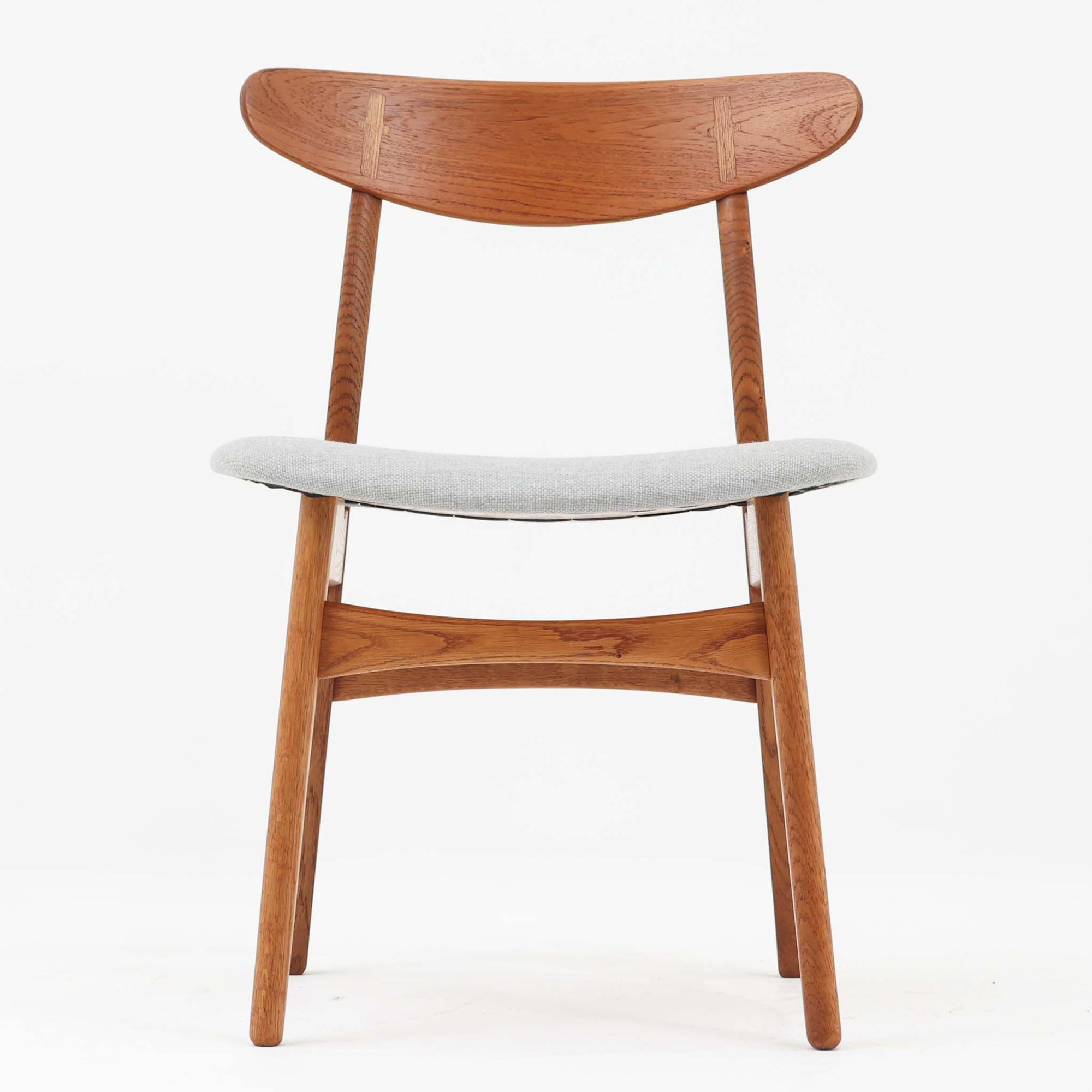 CH30は、ハンス・J・ウェグナーがデザインし、Carl Hansen & Son社によって製造された名作ダイニングチェア。チーク材とオーク材を組み合わせた美しいコントラストが特徴で、木の温もりと洗練されたフォルムが魅力です。特に背もたれと後ろ脚の繋ぎ目は、そのデザインの特徴となっており、独自性とクラフトマンシップの見本と言えるでしょう。背もたれにチーク材が使用された希少なモデルです。人気のため現在復刻されましたが、チーク材とオーク材の組み合わせはビンテージ品でのみ入手可能です。