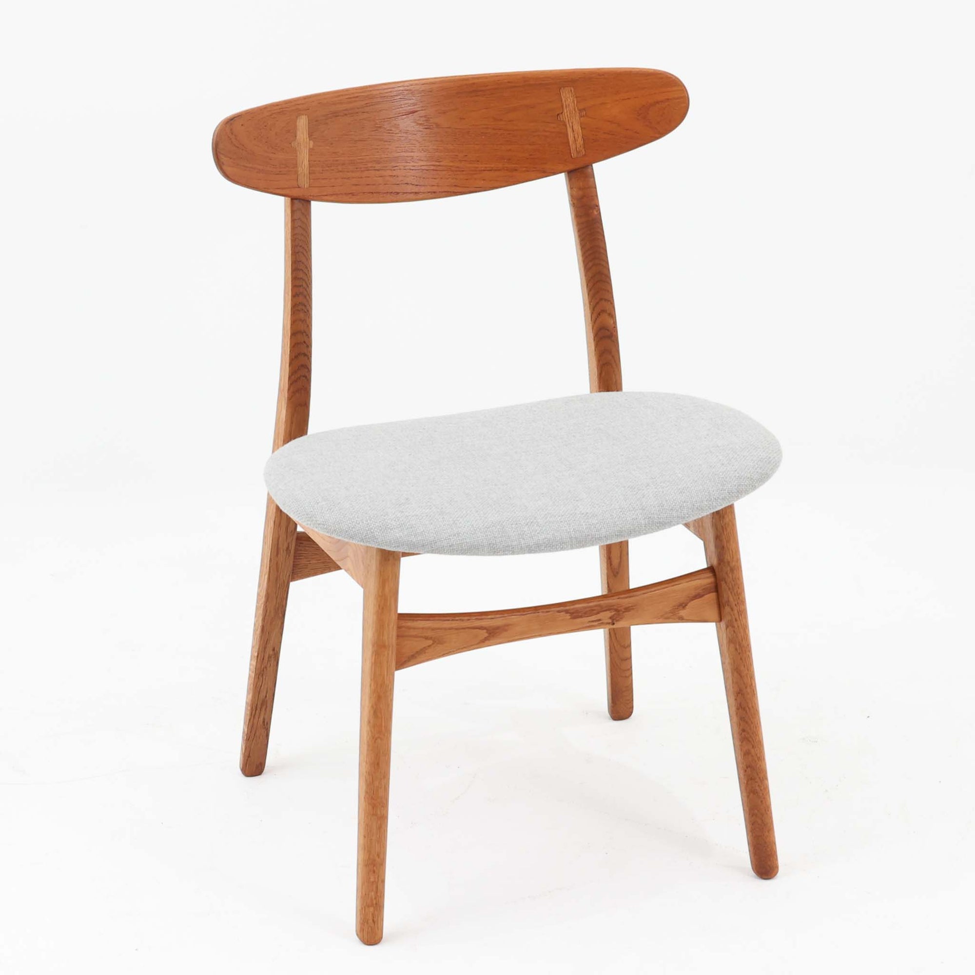 CH30は、ハンス・J・ウェグナーがデザインし、Carl Hansen &amp; Son社によって製造された名作ダイニングチェア。チーク材とオーク材を組み合わせた美しいコントラストが特徴で、木の温もりと洗練されたフォルムが魅力です。特に背もたれと後ろ脚の繋ぎ目は、そのデザインの特徴となっており、独自性とクラフトマンシップの見本と言えるでしょう。背もたれにチーク材が使用された希少なモデルです。人気のため現在復刻されましたが、チーク材とオーク材の組み合わせはビンテージ品でのみ入手可能です。