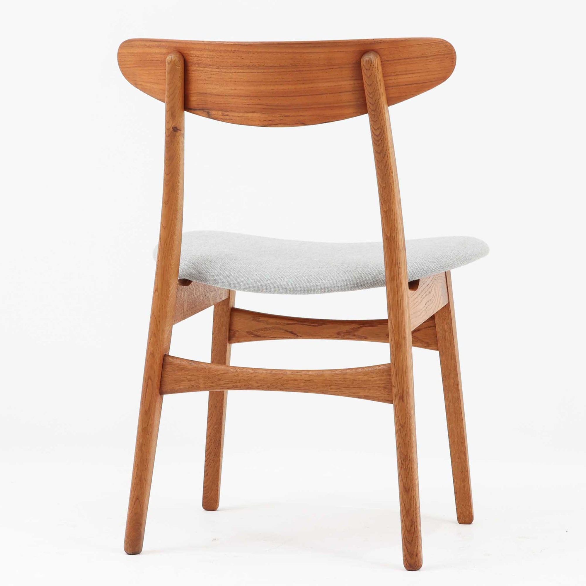 CH30は、ハンス・J・ウェグナーがデザインし、Carl Hansen &amp; Son社によって製造された名作ダイニングチェア。チーク材とオーク材を組み合わせた美しいコントラストが特徴で、木の温もりと洗練されたフォルムが魅力です。特に背もたれと後ろ脚の繋ぎ目は、そのデザインの特徴となっており、独自性とクラフトマンシップの見本と言えるでしょう。背もたれにチーク材が使用された希少なモデルです。人気のため現在復刻されましたが、チーク材とオーク材の組み合わせはビンテージ品でのみ入手可能です。