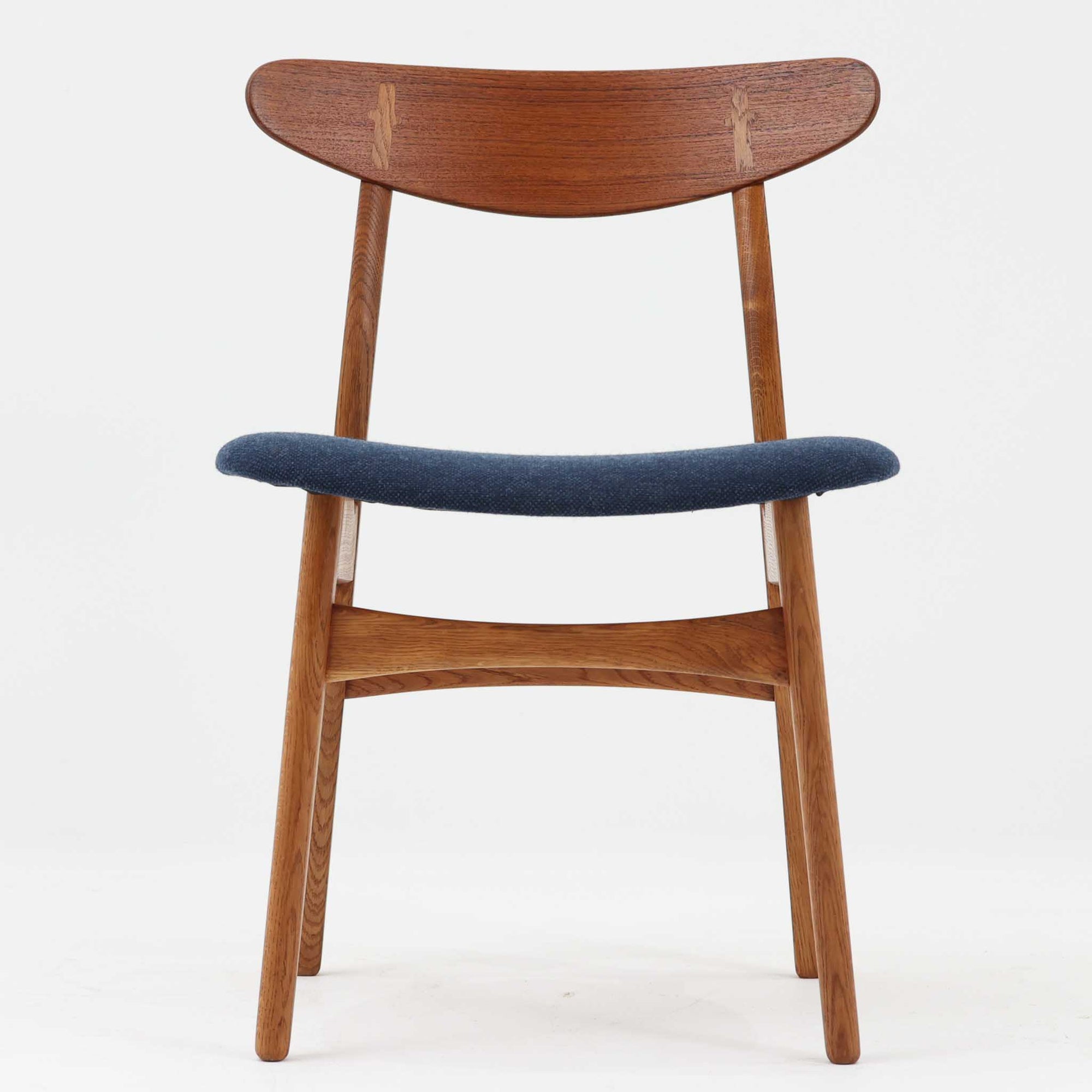 CH30は、ハンス・J・ウェグナーがデザインし、Carl Hansen & Son社によって製造された名作ダイニングチェア。チーク材とオーク材を組み合わせた美しいコントラストが特徴で、木の温もりと洗練されたフォルムが魅力です。特に背もたれと後ろ脚の繋ぎ目は、そのデザインの特徴となっており、独自性とクラフトマンシップの見本と言えるでしょう。背もたれにチーク材が使用された希少なモデルです。人気のため現在復刻されましたが、チーク材とオーク材の組み合わせはビンテージ品でのみ入手可能です。