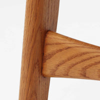 CH30は、ハンス・J・ウェグナーがデザインし、Carl Hansen & Son社によって製造された名作ダイニングチェア。チーク材とオーク材を組み合わせた美しいコントラストが特徴で、木の温もりと洗練されたフォルムが魅力です。特に背もたれと後ろ脚の繋ぎ目は、そのデザインの特徴となっており、独自性とクラフトマンシップの見本と言えるでしょう。背もたれにチーク材が使用された希少なモデルです。人気のため現在復刻されましたが、チーク材とオーク材の組み合わせはビンテージ品でのみ入手可能です。