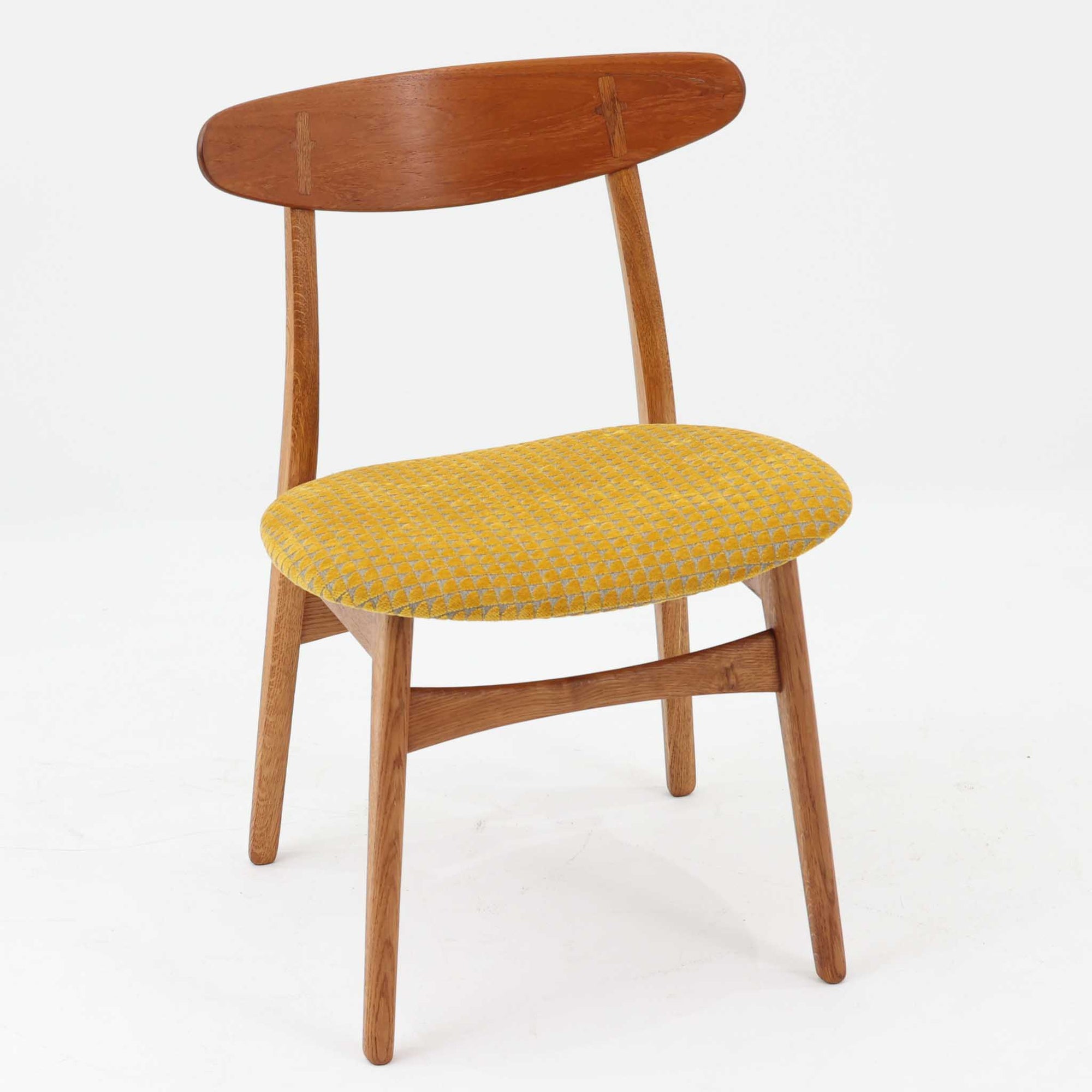 CH30は、ハンス・J・ウェグナーがデザインし、Carl Hansen &amp; Son社によって製造された名作ダイニングチェア。チーク材とオーク材を組み合わせた美しいコントラストが特徴で、木の温もりと洗練されたフォルムが魅力です。特に背もたれと後ろ脚の繋ぎ目は、そのデザインの特徴となっており、独自性とクラフトマンシップの見本と言えるでしょう。背もたれにチーク材が使用された希少なモデルです。人気のため現在復刻されましたが、チーク材とオーク材の組み合わせはビンテージ品でのみ入手可能です。