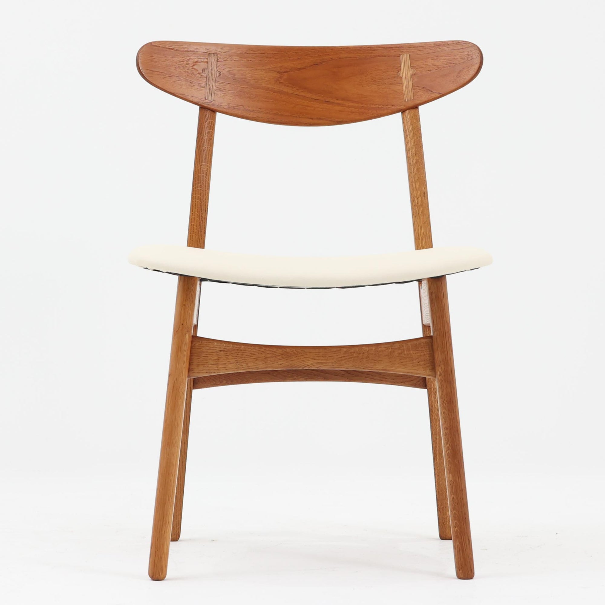 CH30は、ハンス・J・ウェグナーがデザインし、Carl Hansen & Son社によって製造された名作ダイニングチェア。チーク材とオーク材を組み合わせた美しいコントラストが特徴で、木の温もりと洗練されたフォルムが魅力です。特に背もたれと後ろ脚の繋ぎ目は、そのデザインの特徴となっており、独自性とクラフトマンシップの見本と言えるでしょう。背もたれにチーク材が使用された希少なモデルです。人気のため現在復刻されましたが、チーク材とオーク材の組み合わせはビンテージ品でのみ入手可能です。