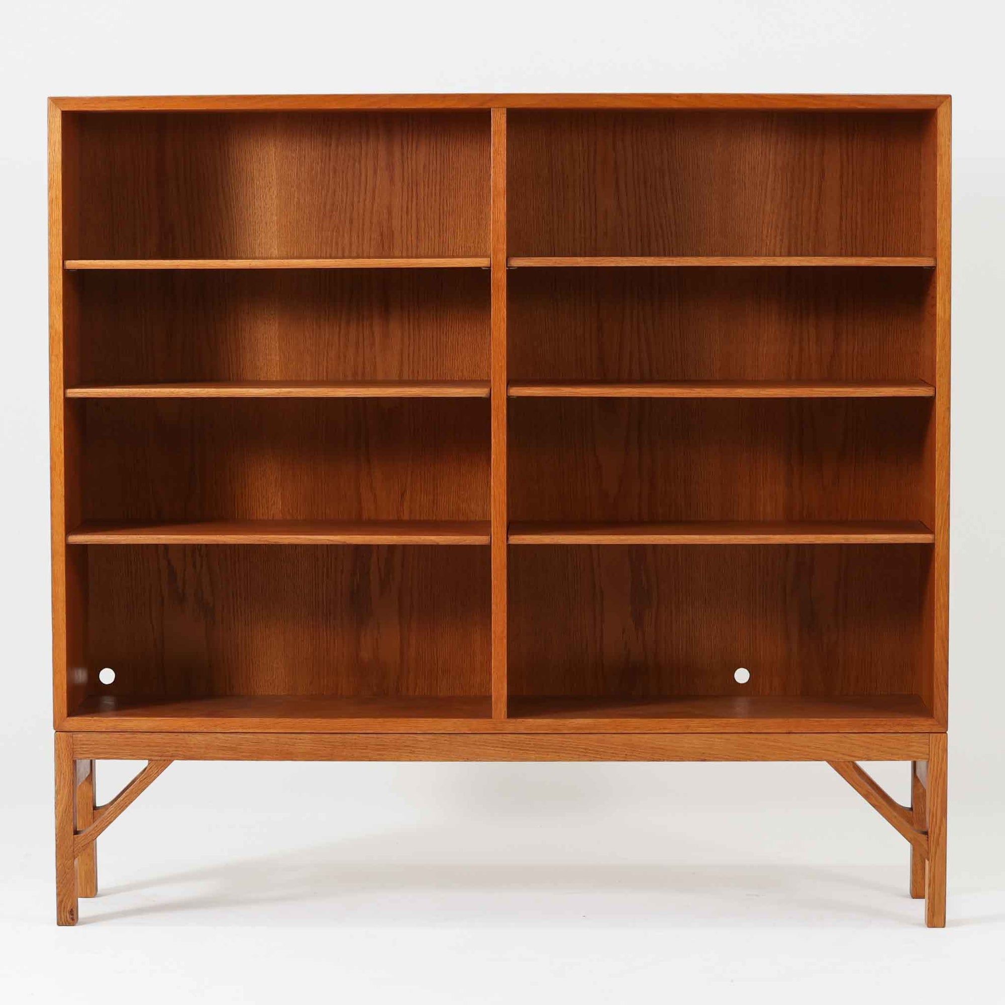 ボーエ・モーエンセンが手がけ、FDB Moblerより製作された北欧ビンテージのブックシェルフです。オーク材の木目を活かした端正で実直な佇まいは、生活に寄り添う家具を追求したデザイン哲学を色濃く感じさせます。左右に分かれた棚構成は収納力に優れ、書籍や器、オブジェまで整然と収められる構造です。特徴的な脚部は後年に付け替えられたものではなく、FDB社で製造されたオリジナル仕様で、取り外すと刻印が確認できます。全体に軽やかさと安定感を与える脚部と、長年の使用によって深みを増した素材感が相まい、空間に静かな存在感とビンテージならではの魅力を添える一台です。