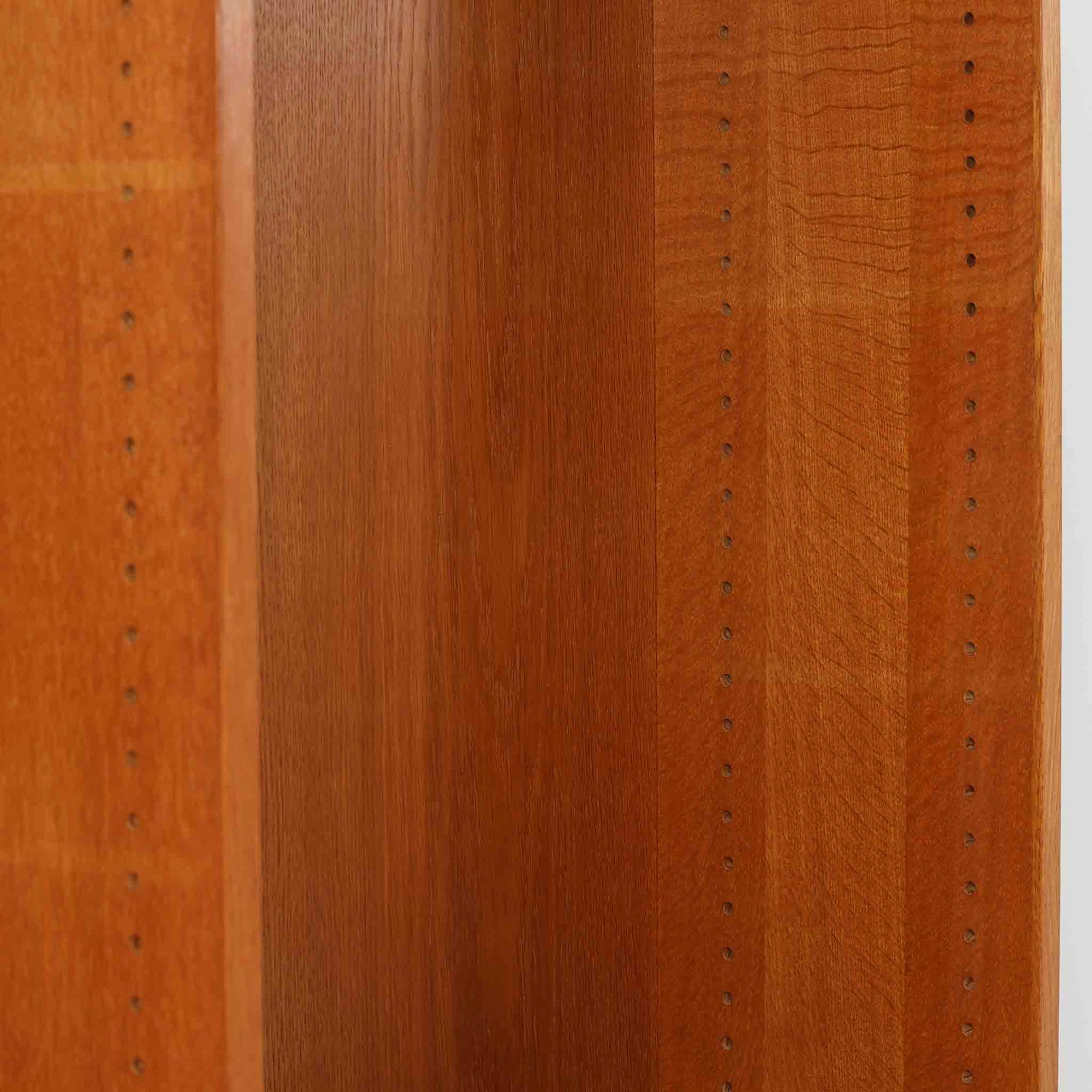 ボーエ・モーエンセンが手がけ、FDB Moblerより製作された北欧ビンテージのブックシェルフです。オーク材の木目を活かした端正で実直な佇まいは、生活に寄り添う家具を追求したデザイン哲学を色濃く感じさせます。左右に分かれた棚構成は収納力に優れ、書籍や器、オブジェまで整然と収められる構造です。特徴的な脚部は後年に付け替えられたものではなく、FDB社で製造されたオリジナル仕様で、取り外すと刻印が確認できます。全体に軽やかさと安定感を与える脚部と、長年の使用によって深みを増した素材感が相まい、空間に静かな存在感とビンテージならではの魅力を添える一台です。