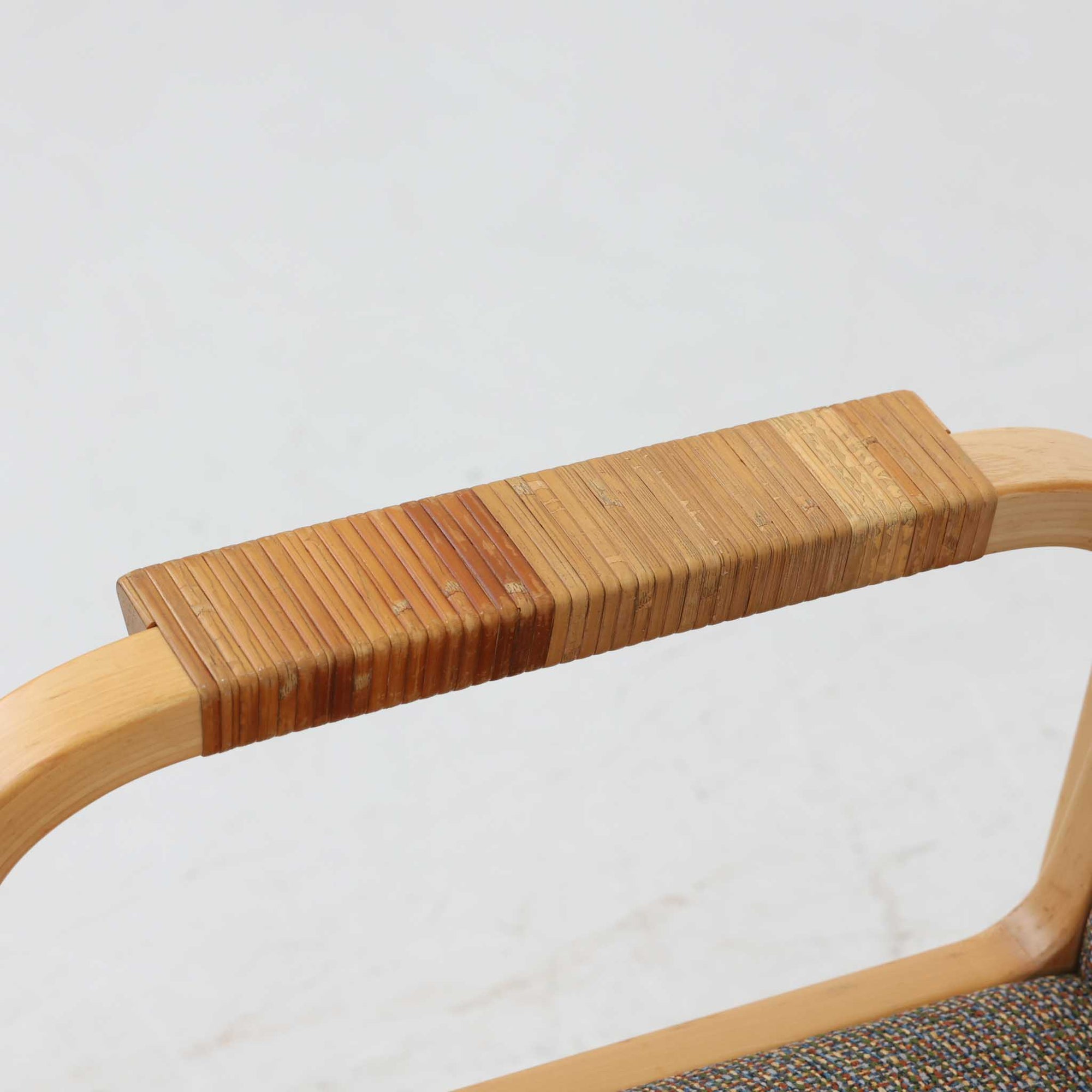 アルヴァ・アアルトが手掛け、アルテックより製作されたモデルE45のアームチェアは、積層バーチ材による滑らかなフレームと、アーム上部に施されたラタン巻きが特徴的な北欧ビンテージの名作です。直線と曲線を巧みに組み合わせた構造は、視覚的な軽やかさと高い強度を両立し、背と座には張りのあるファブリックを用いることで、長時間でも快適な座り心地を実現しています。使い込むほどに木部の色味が深まり、素材の経年変化を楽しめる点も魅力で、ダイニングや書斎、公共空間まで幅広いシーンで活躍する一脚です。